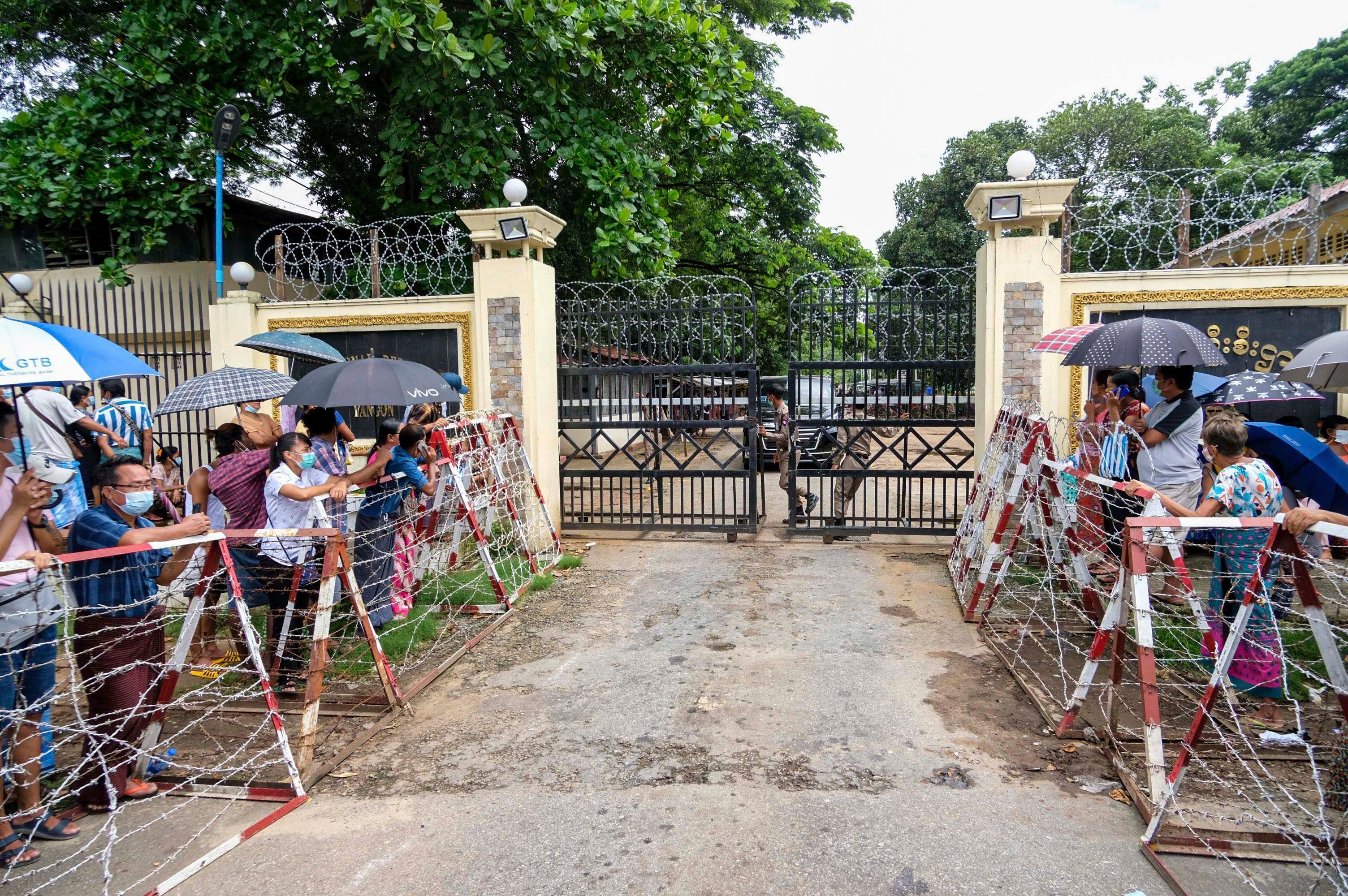 People stand outside the gates of a prison 