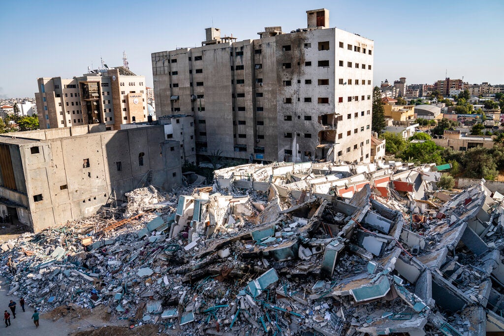 People in Gaza stand near the site of the collapsed al-Jalaa tower 