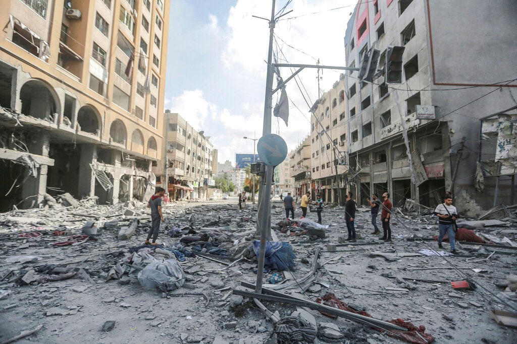 People in Gaza stand in the debris on al-Jalaa street