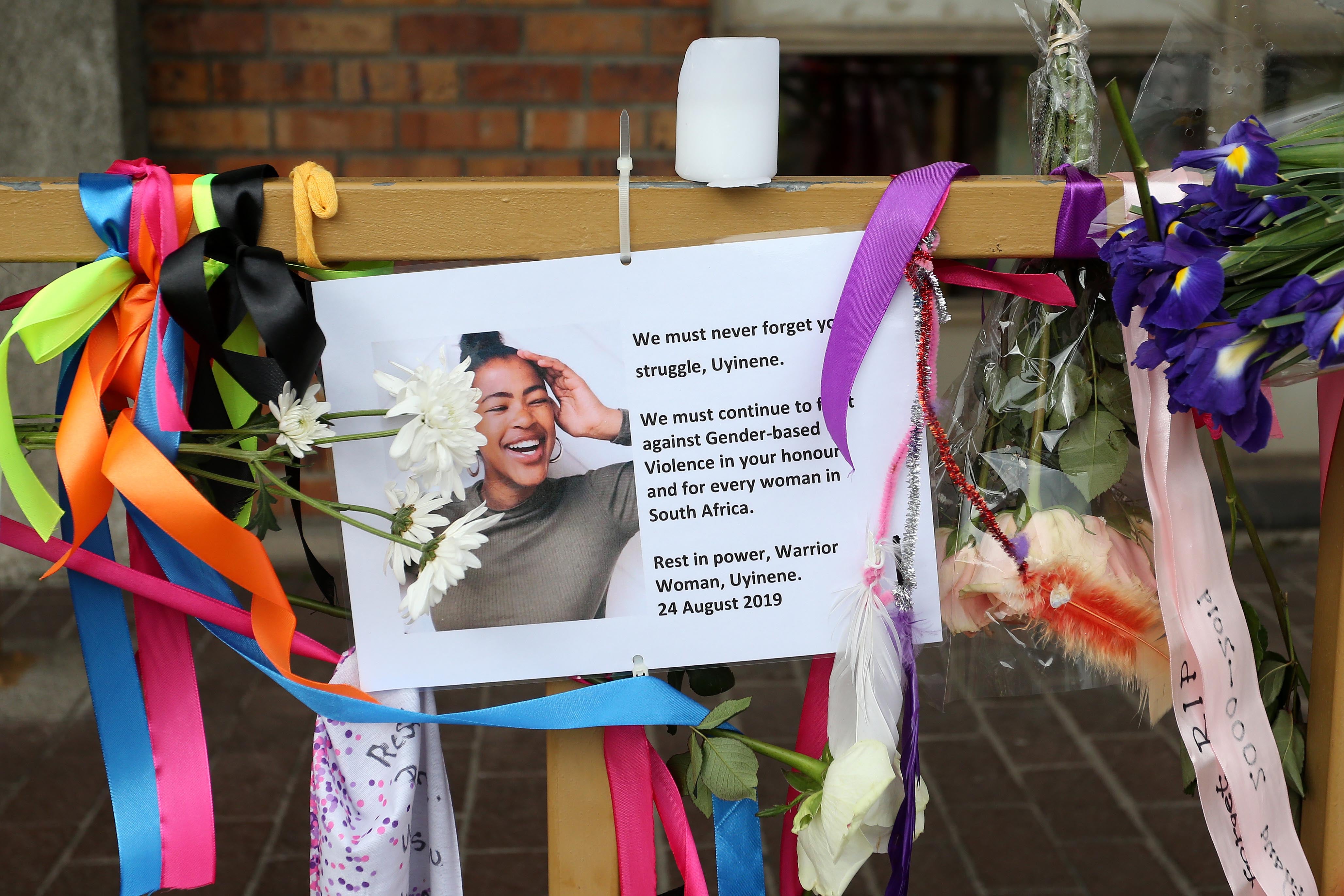 A memorial sign surrounded with ribbons and flowers