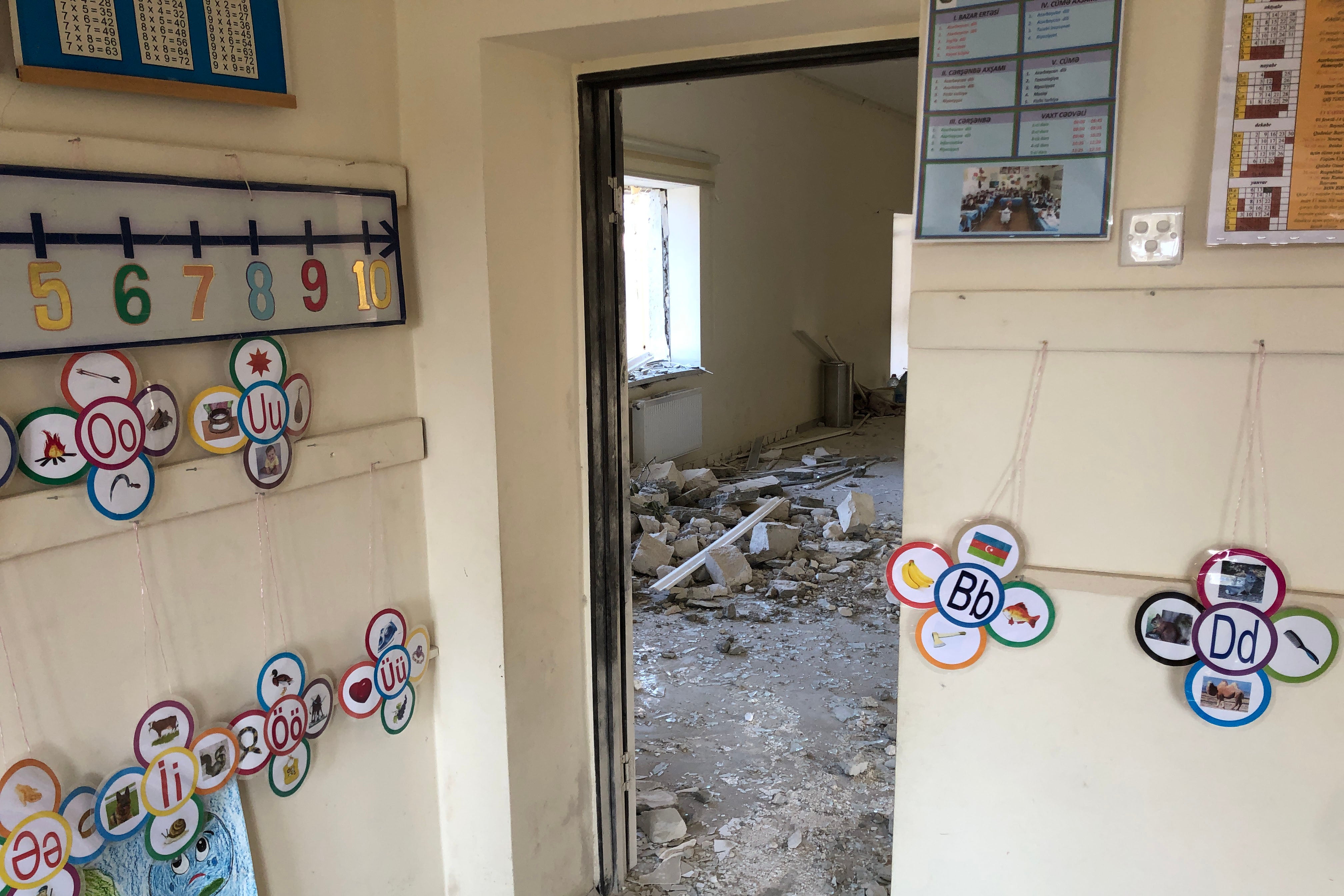 Interior of a classroom with rubble and broken windows