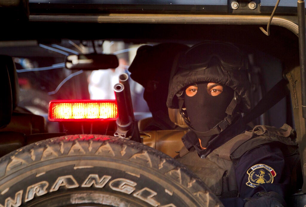 A masked Egyptian policeman watches Tahrir Square in Cairo, Egypt.