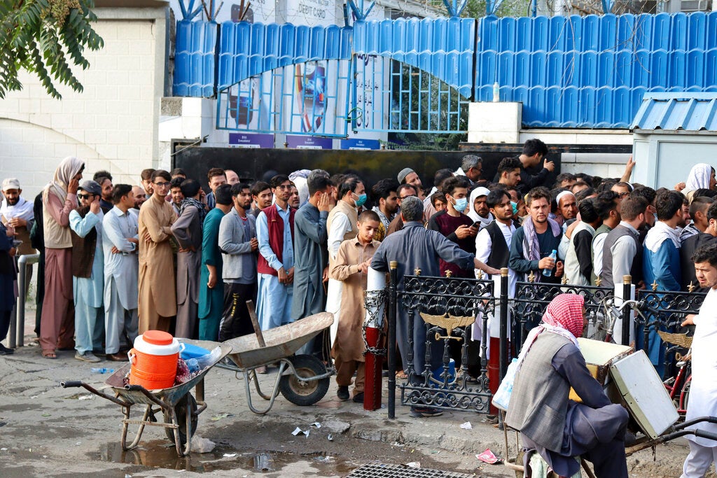 Afghans wait for hours to try to withdraw money from a bank in Kabul, Afghanistan, August 30, 2021. 