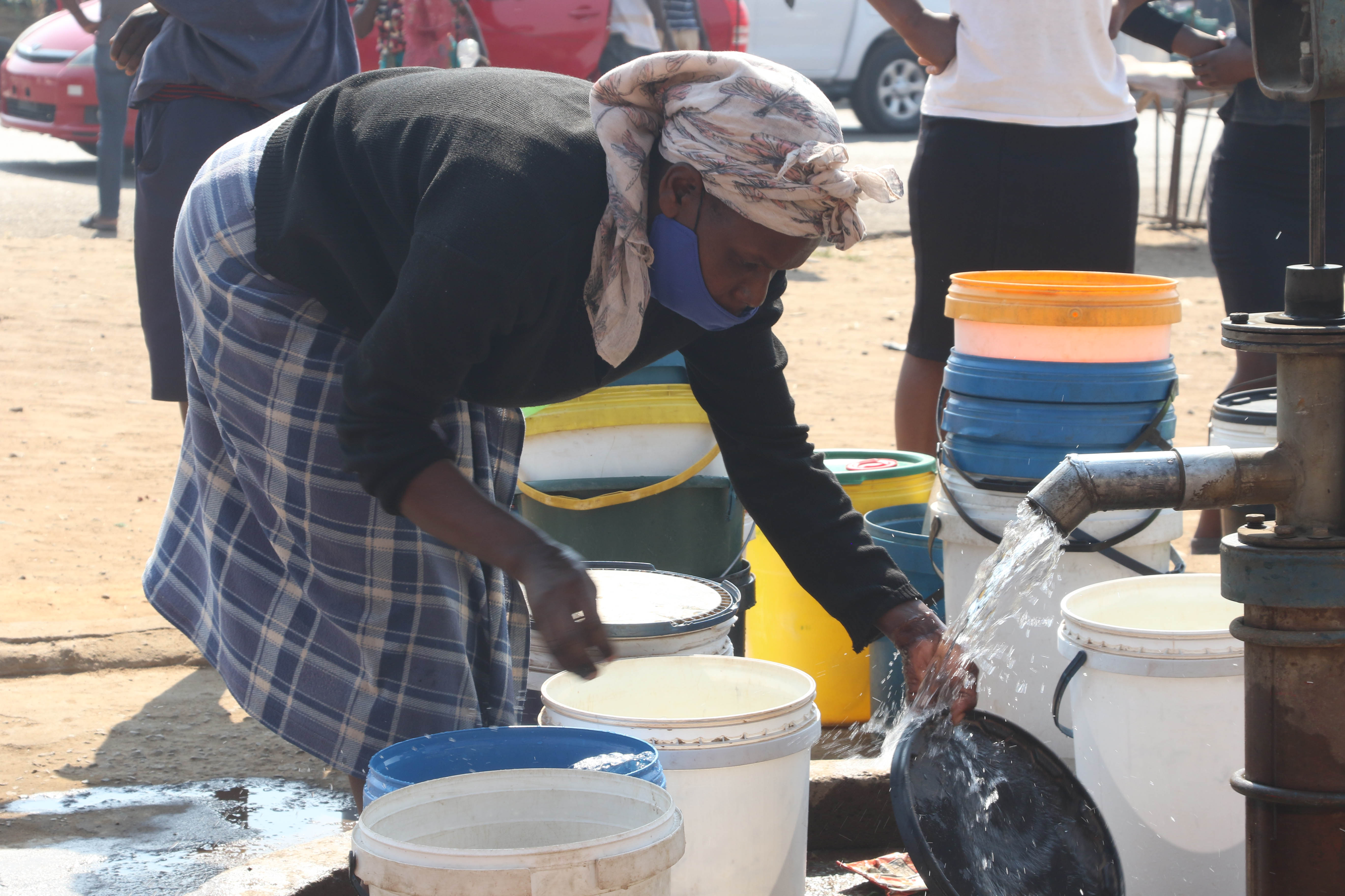 Cette femme recueillait de l'eau issue d’un puits forage dans le quartier de Mabvuku à Harare, la capitale du Zimbabwe, le 28 août 2021.