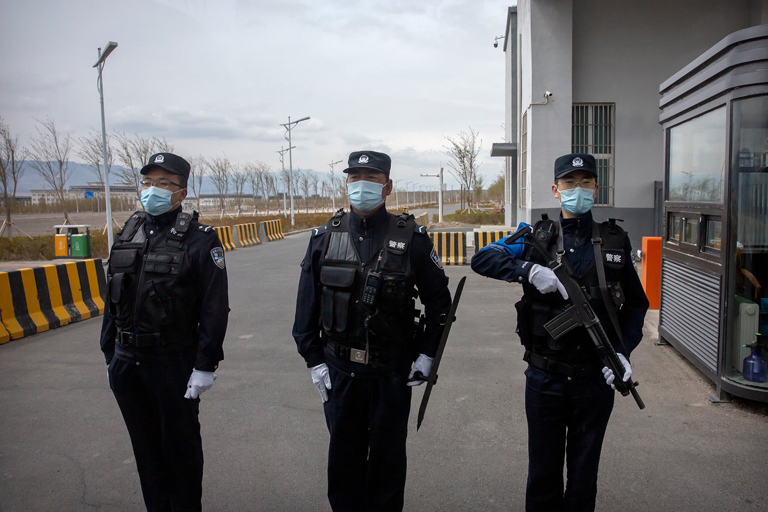 Ces trois policiers chinois gardaient l'entrée du centre de détention n°3 d'Urumqi à Dabancheng, dans la région du Xinjiang, dans l'ouest de la Chine, le 23 avril 2021.