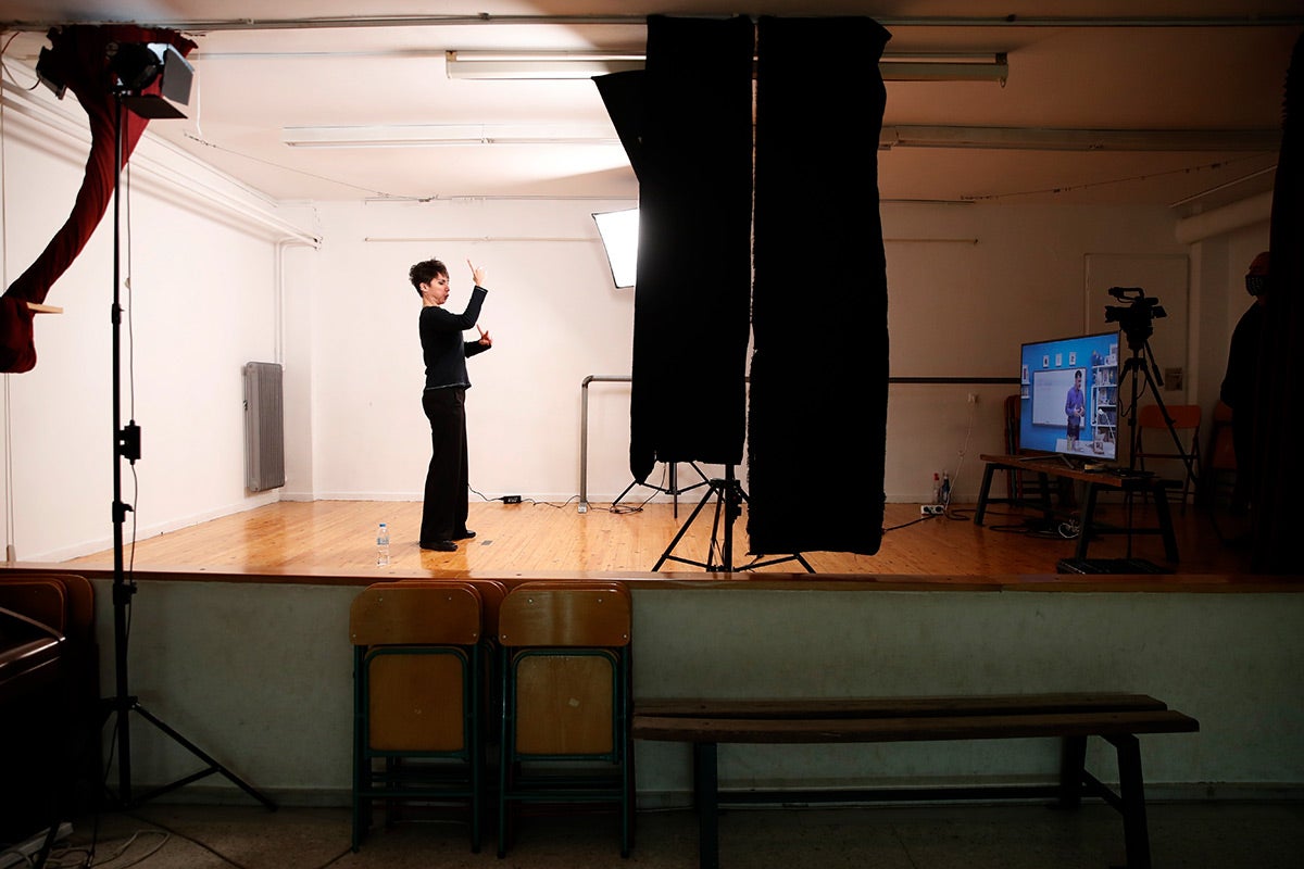 A sign language interpreter records sign language lessons that are broadcast on public television, at an elementary school in Athens, Friday, Nov. 20, 2020. 