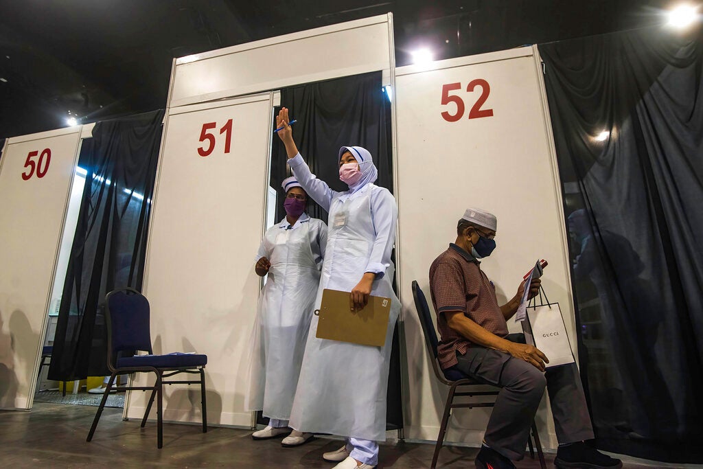 A health worker gestures to the next vaccine recipient at Malaysia International Trade & Exhibition Centre in Kuala Lumpur, Malaysia on May 31, 2021.