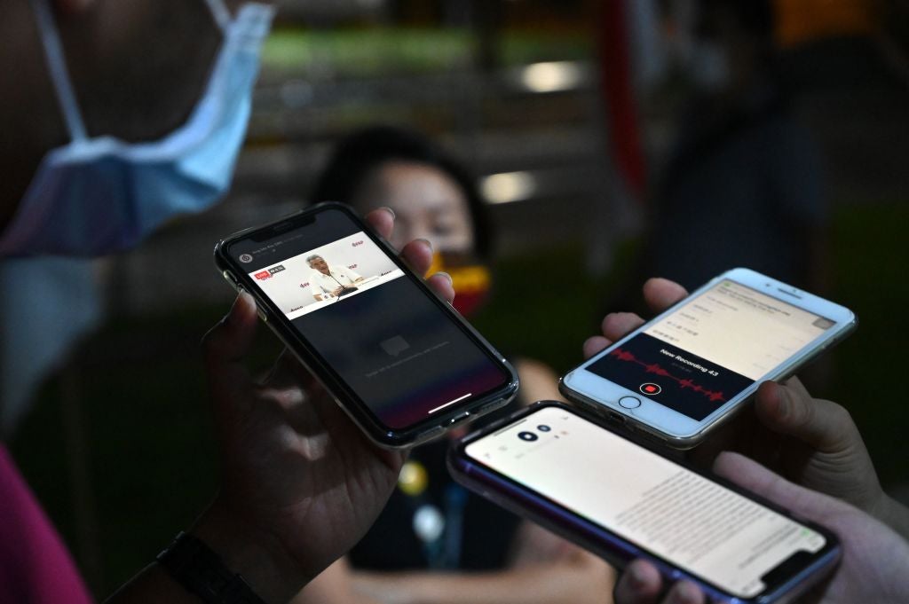 Reporters record a speech by Singapore's Prime Minister Lee Hsien Loong as it is streamed on Facebook live during vote counting in the general election in Singapore, July 11, 2020. 