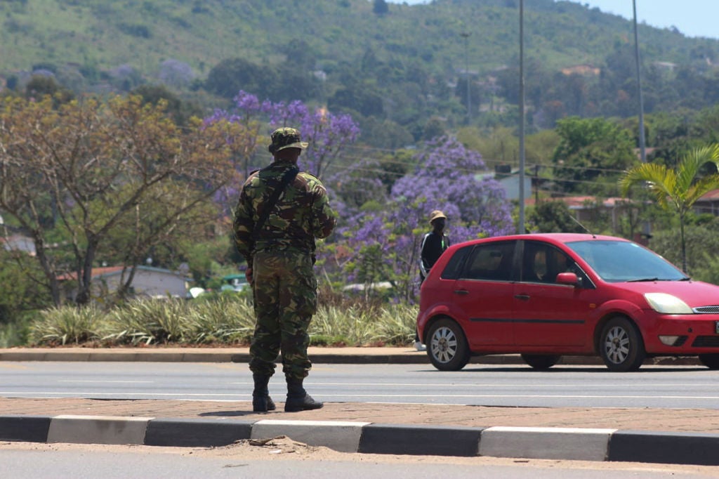 A soldier stands in the road in Manzini on October 20, 2021 where at least 80 people were injured in Eswatini.