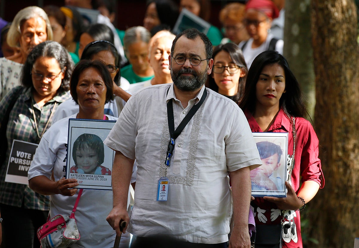 Commission on Human Rights Chair Chito Gascon, center, leads families of victims of alleged extrajudicial killings in the "war on drugs" in a march calling for an investigation by the UN Human Rights Council in Manila, Philippines, July 9, 2019.