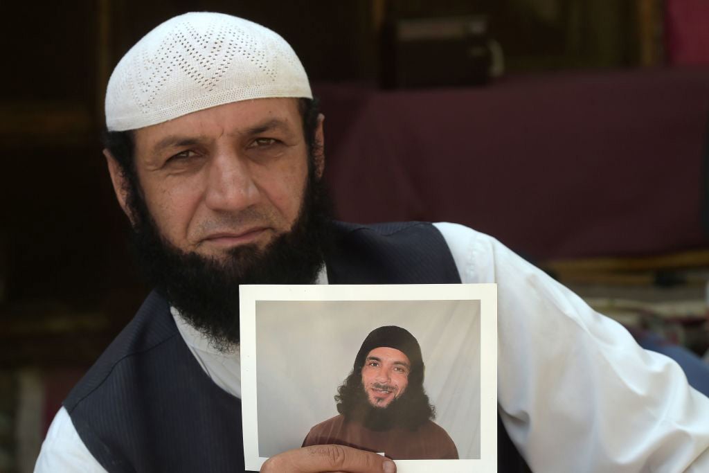 Afghan refugee Roman Khan at a refugee camp near Pakistan's northwestern city of Peshawar in September 2020, displays a photograph of his brother Asadullah Haroon, who is detained at the Guantanamo Bay detention center.