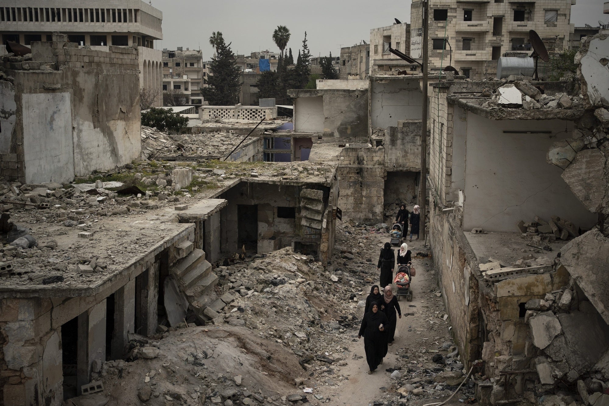 Women walk in a neighborhood heavily damaged by airstrikes in Idlib, Syria on March 12, 2020. Idlib governorate is the last area under anti-government control in Syria. 