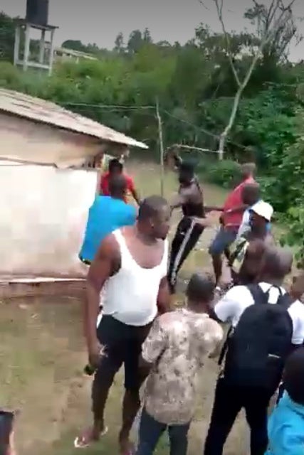 A blurry screenshot from a video showing a mob of men 