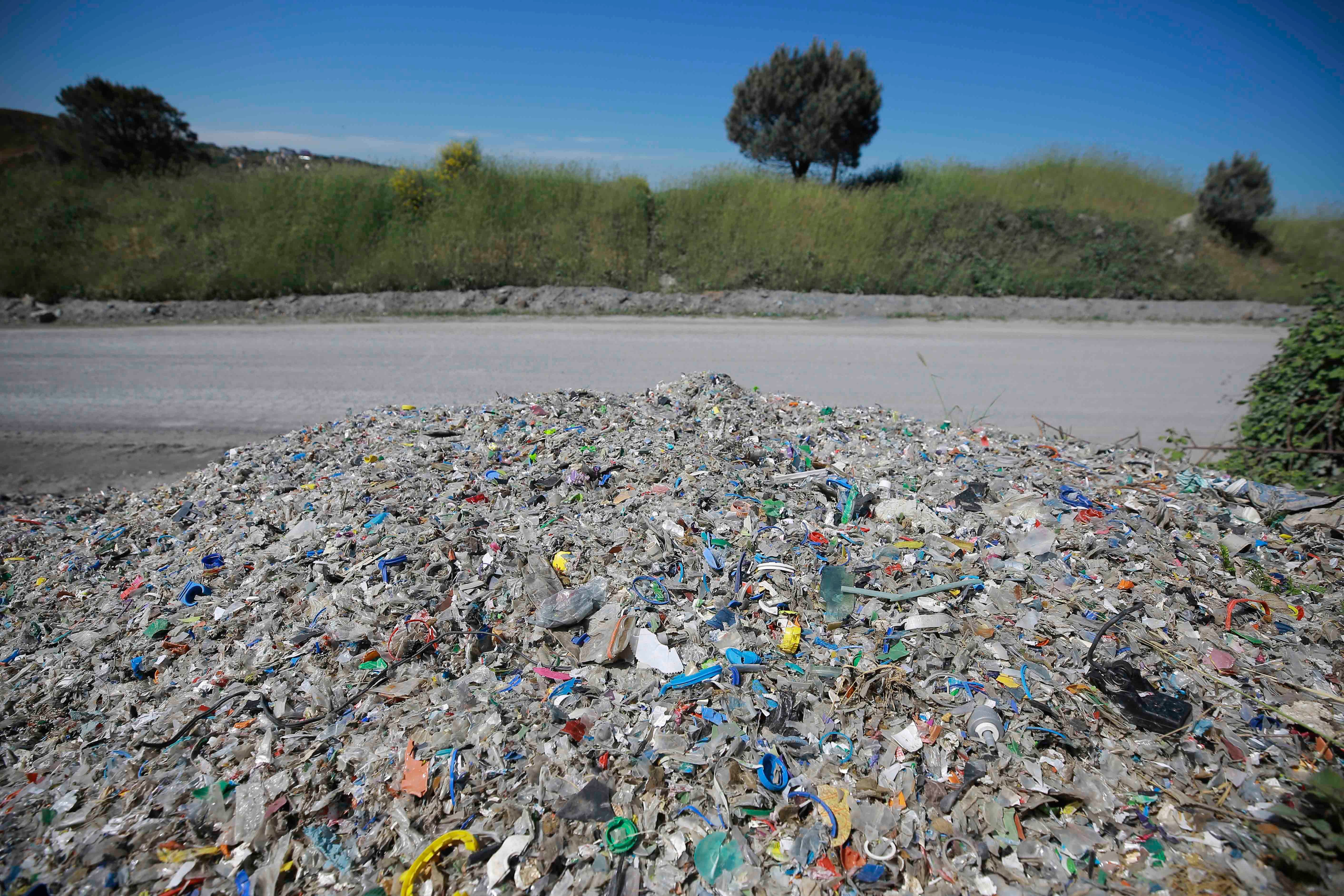 A pile of garbage and waste next to a road