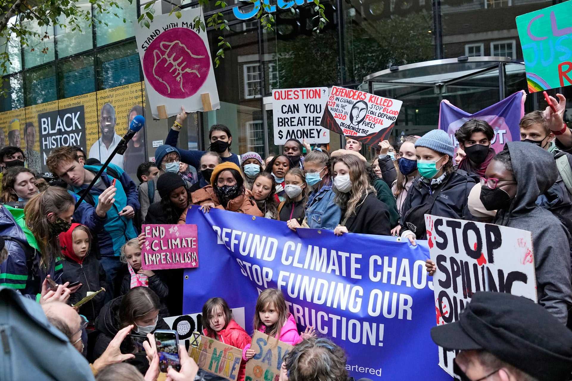 Climate activist Greta Thunberg, center, demonstrates with others in front of the Standard and Chartered Bank during a climate protest in London, England, October 29, 2021