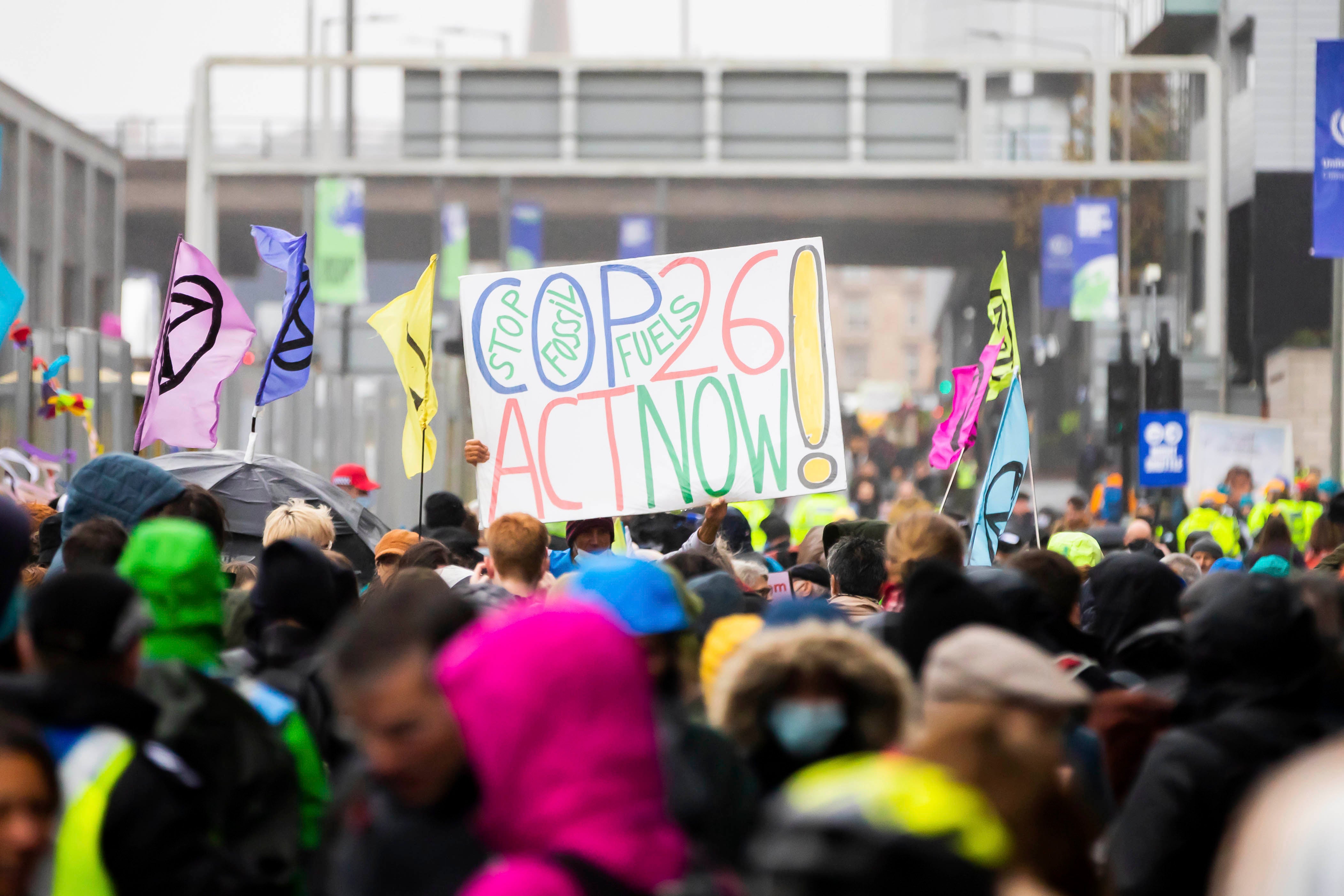 12 November 2021, United Kingdom, Glasgow: A poster calling for better climate protection is held aloft during a protest outside the grounds of the UN Climate Change Conference COP26. Photo by: Christoph Soeder/picture-alliance/dpa/AP Images