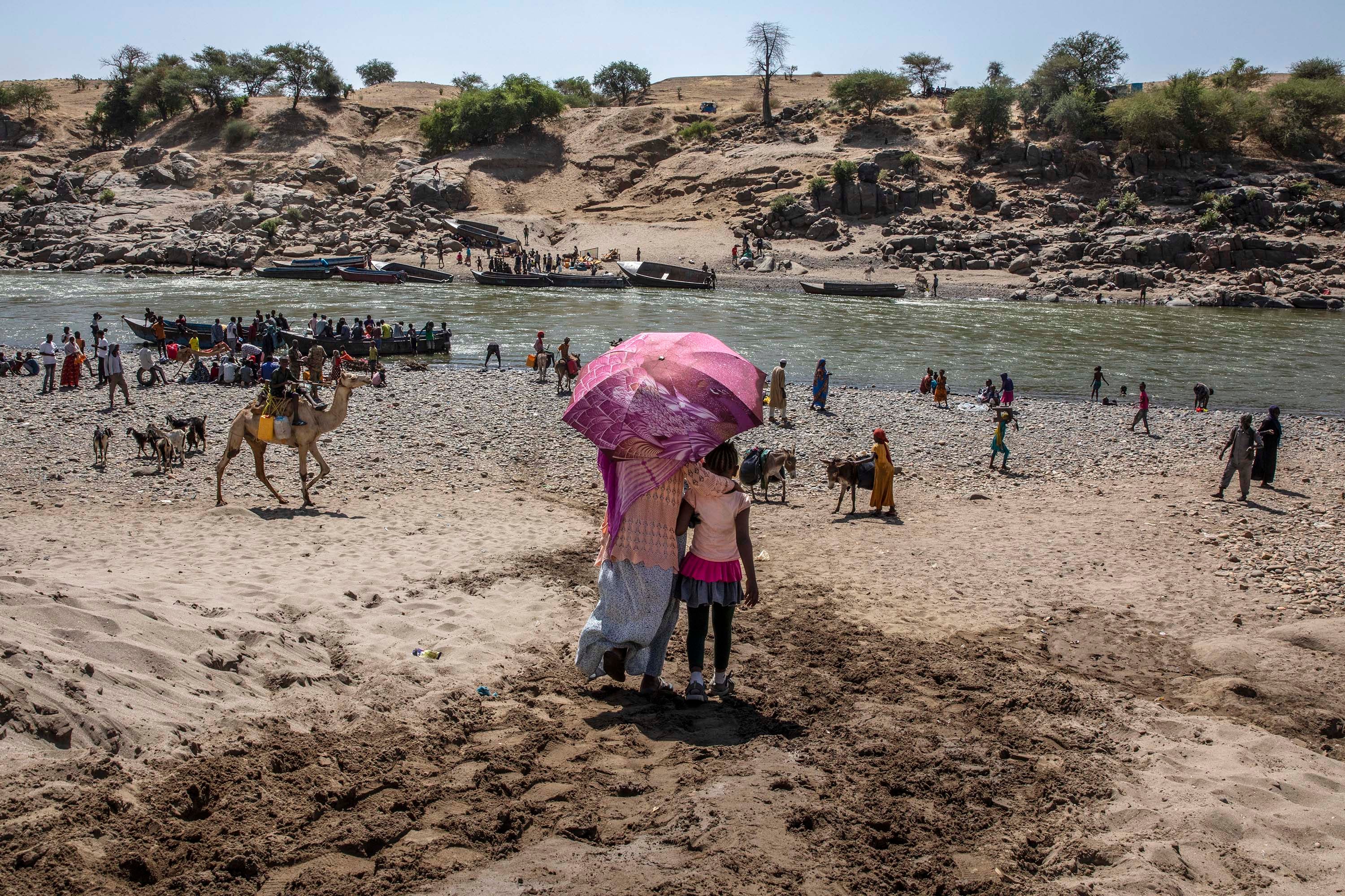 Refugees who fled the conflict in Ethiopia's Tigray region arrive on the banks of the Tekeze River on the Sudan-Ethiopia border, in Hamdayet, eastern Sudan, November 21, 2020.