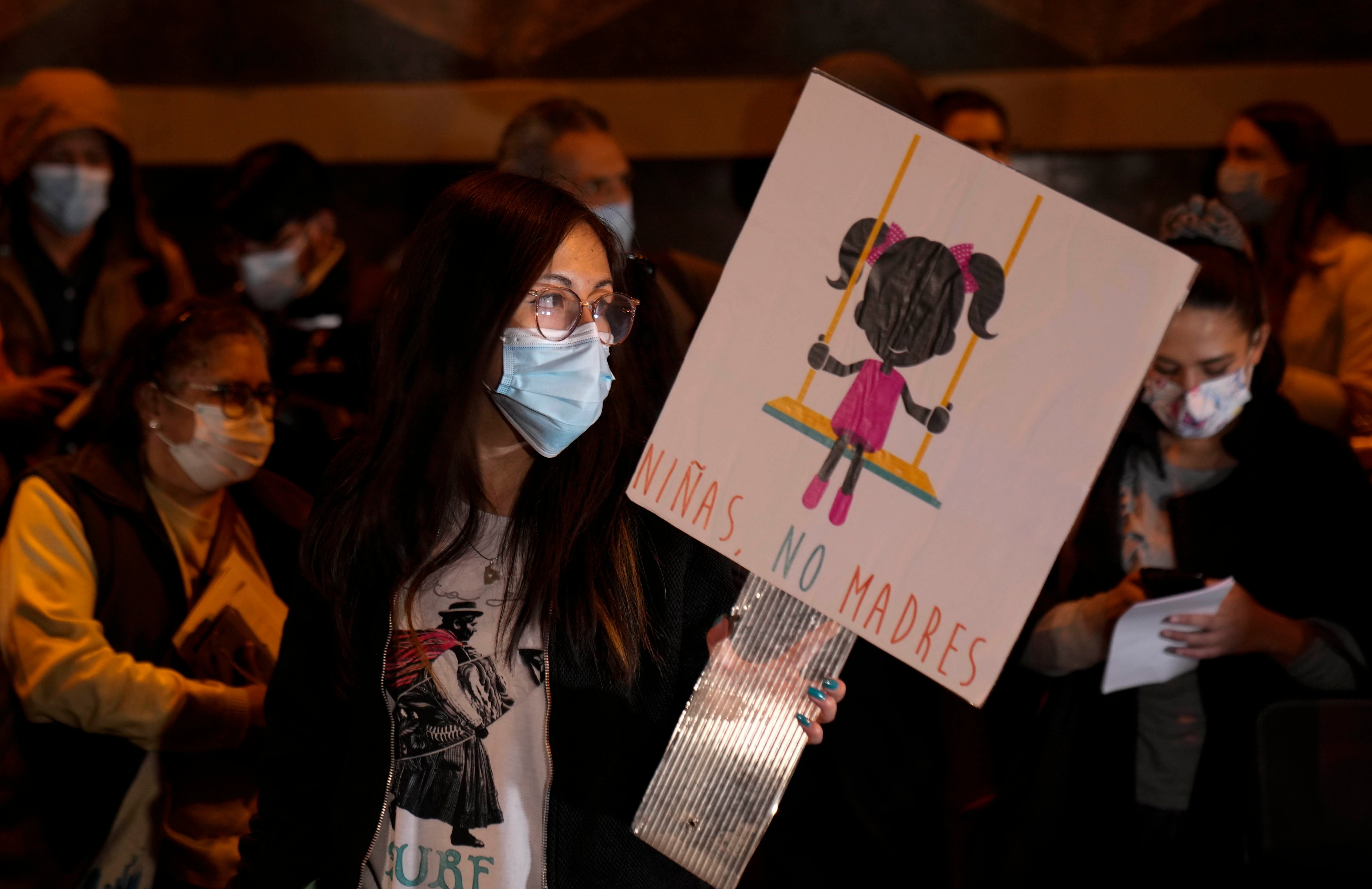 Una mujer sostiene una pancarta que dice "Niñas, no madres", durante una manifestación por los derechos sexuales y reproductivos en La Paz, Bolivia, el 27 de octubre de 2021. El caso de una niña de 11 años que quedó embarazada tras ser violada repetidamente por un familiar reanudó el debate sobre el aborto en Bolivia.