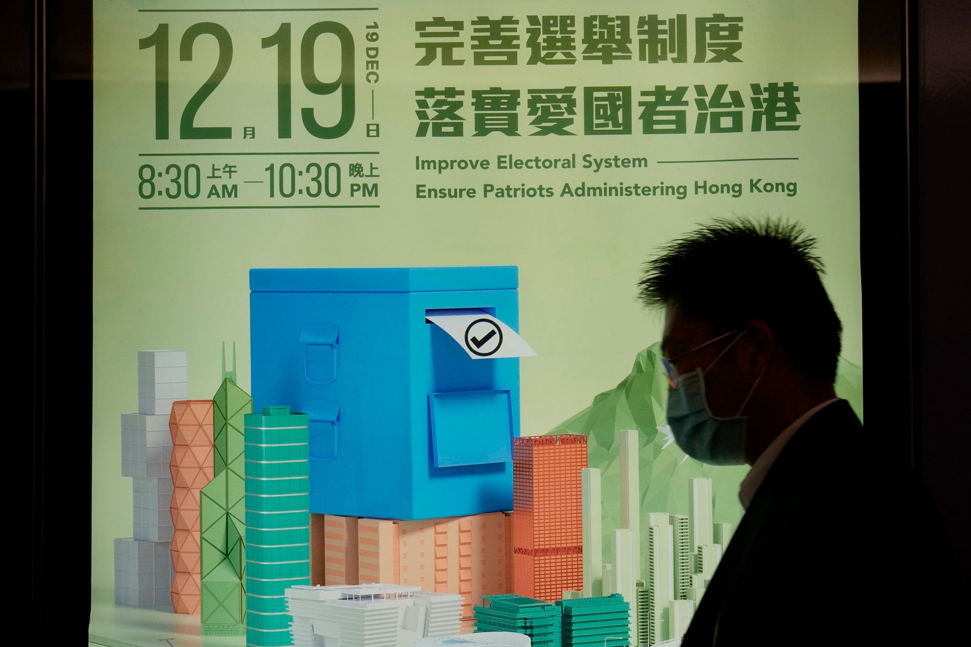 一名男子在將舉行的香港立法會選舉宣傳海報前走過，2021年11月23日。