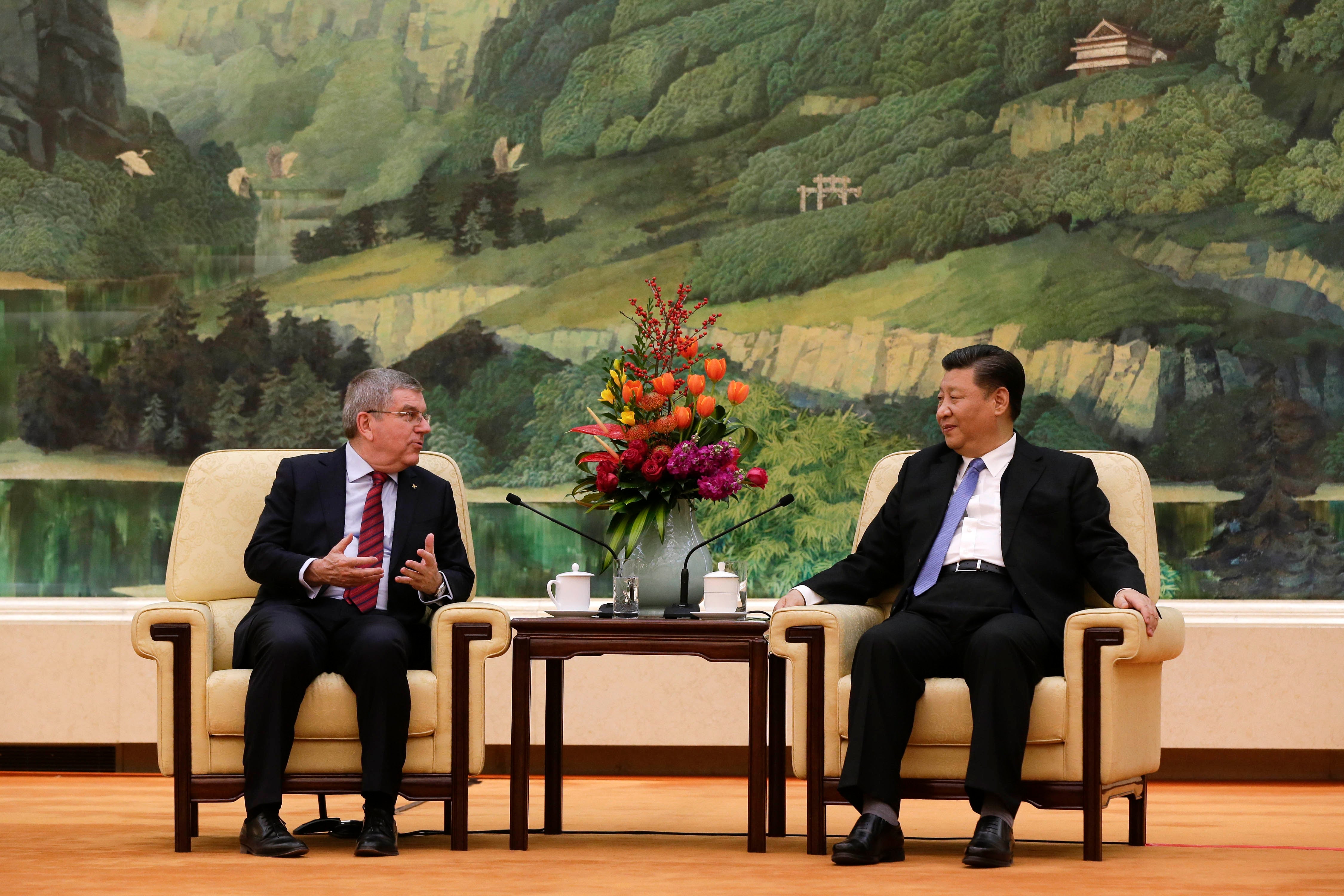 Two men speak to each other while seated