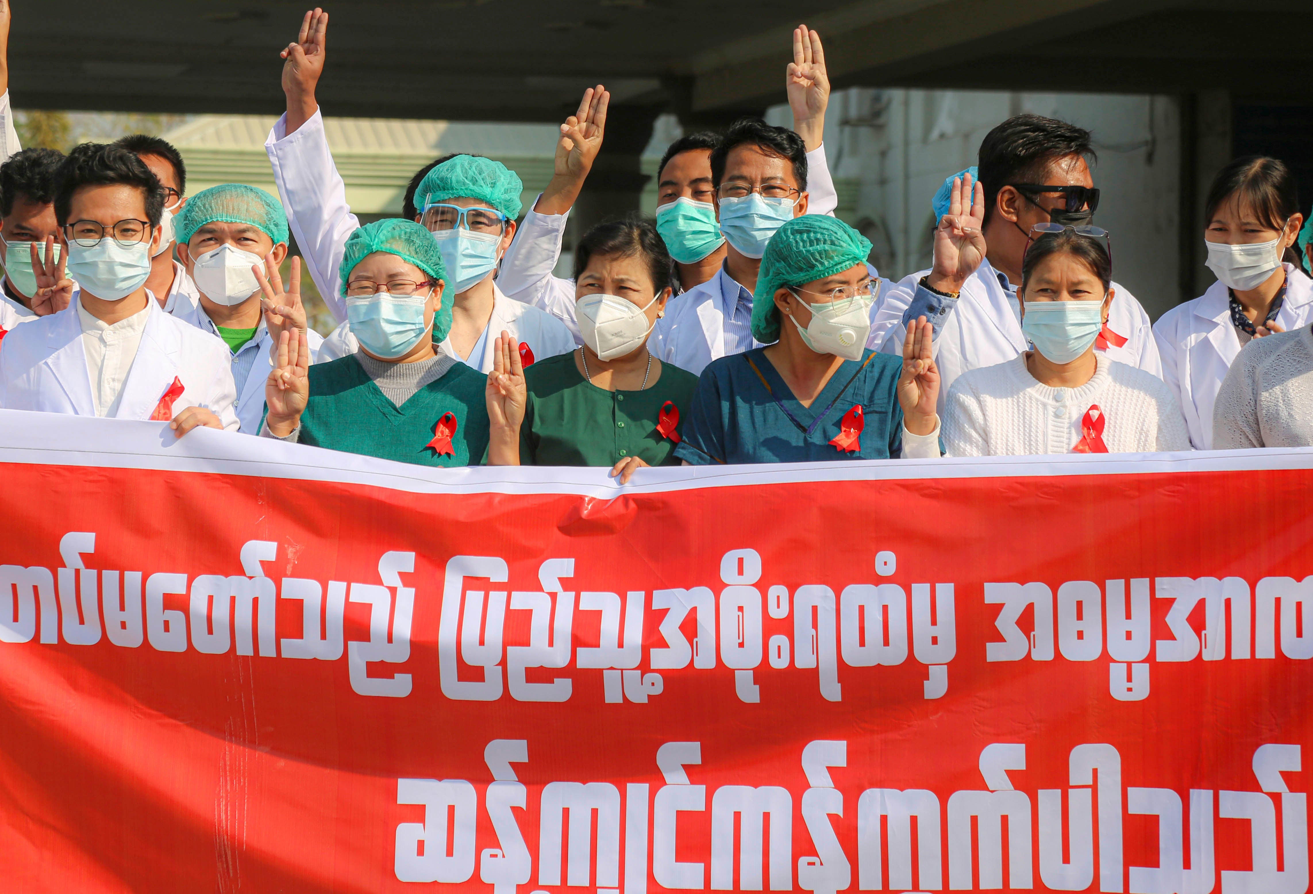 Ces travailleuses et travailleurs de la santé participaient à une manifestation de la « Campagne du ruban rouge » devant un hôpital de Mandalay, au Myanmar, pour protester contre le coup d'État militaire, le 3 février 2021.