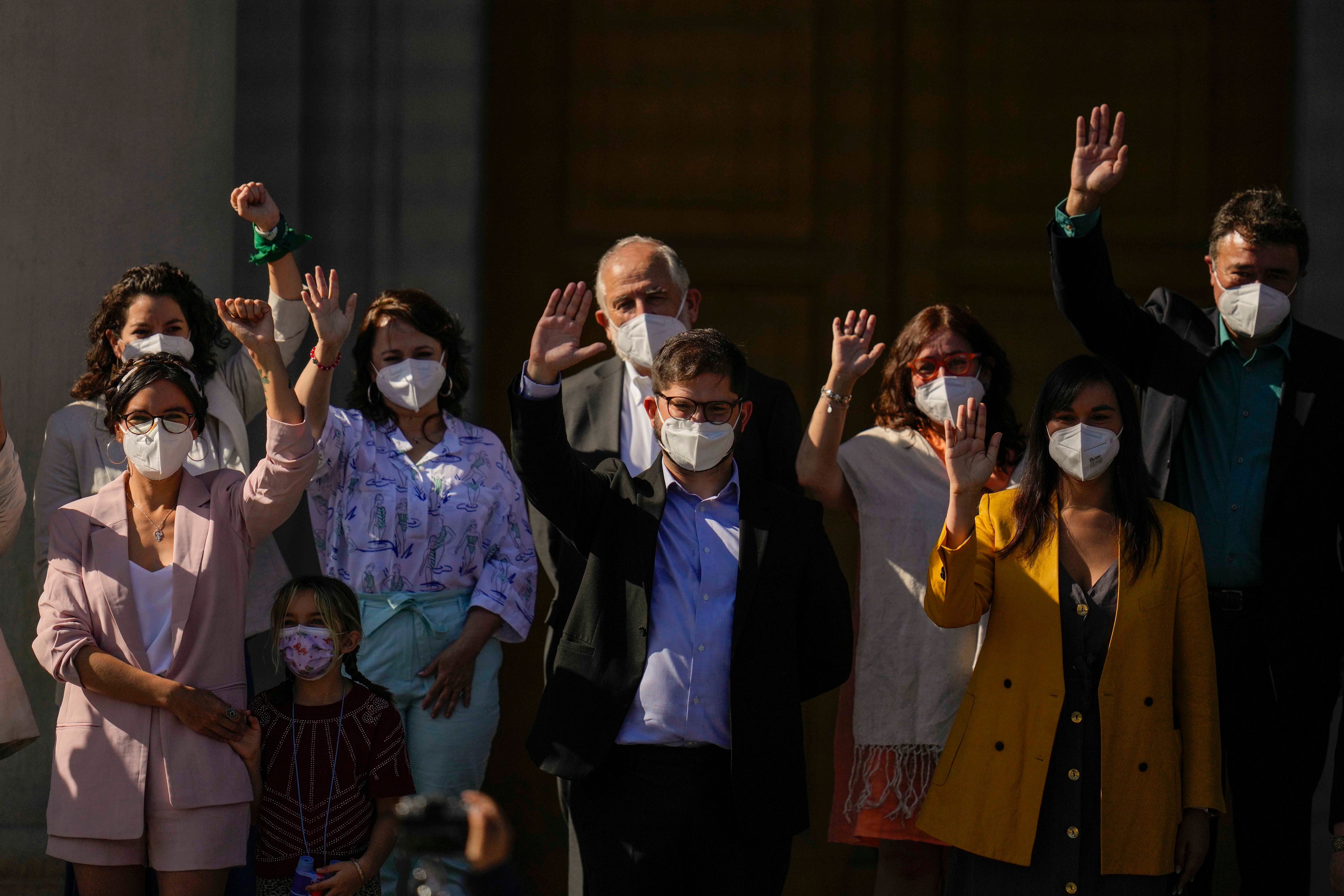 People waving with face masks on 
