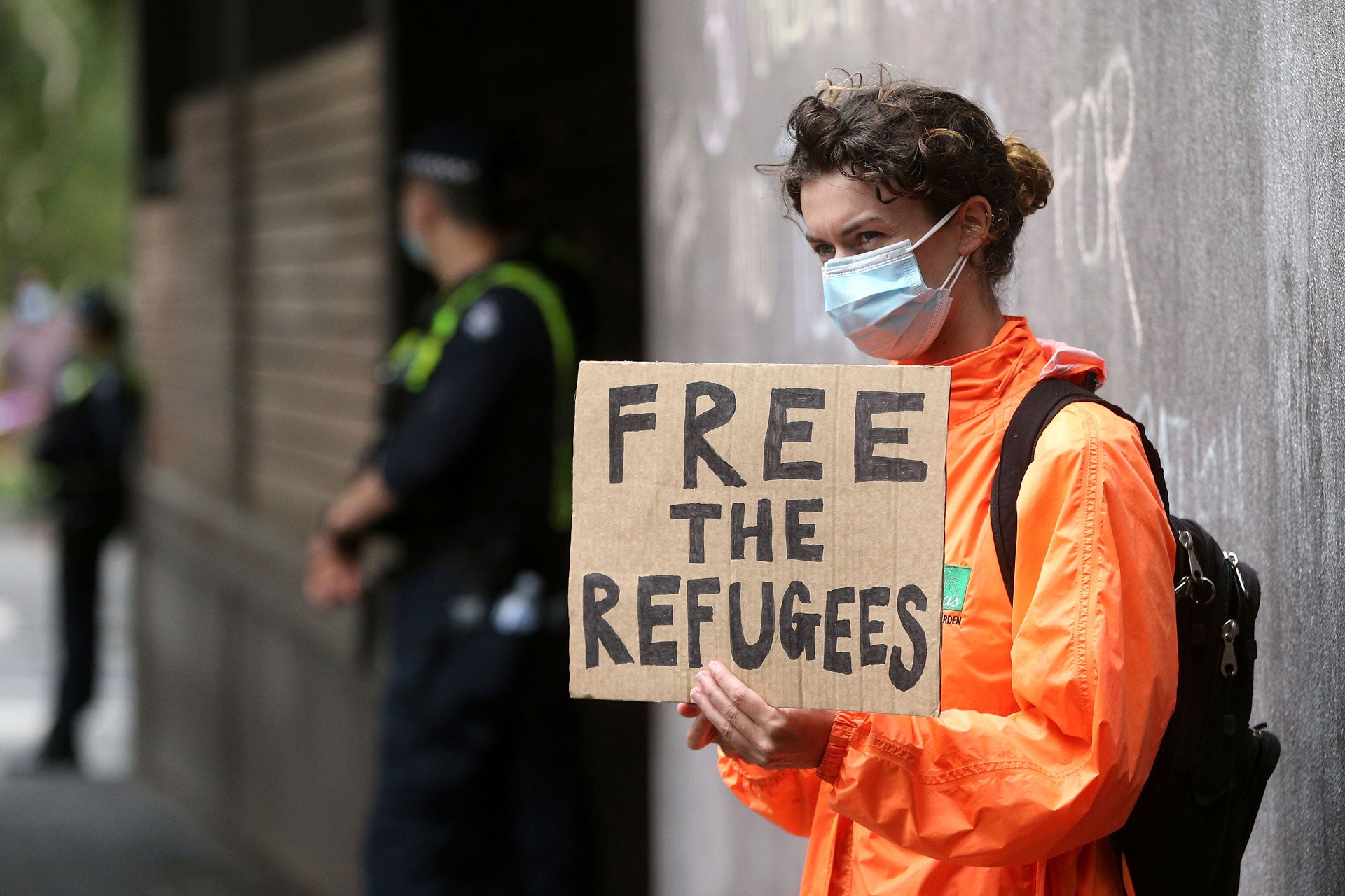 A protester holds a sign calling for the release of refugees being detained inside the Park Hotel in Melbourne, Australia