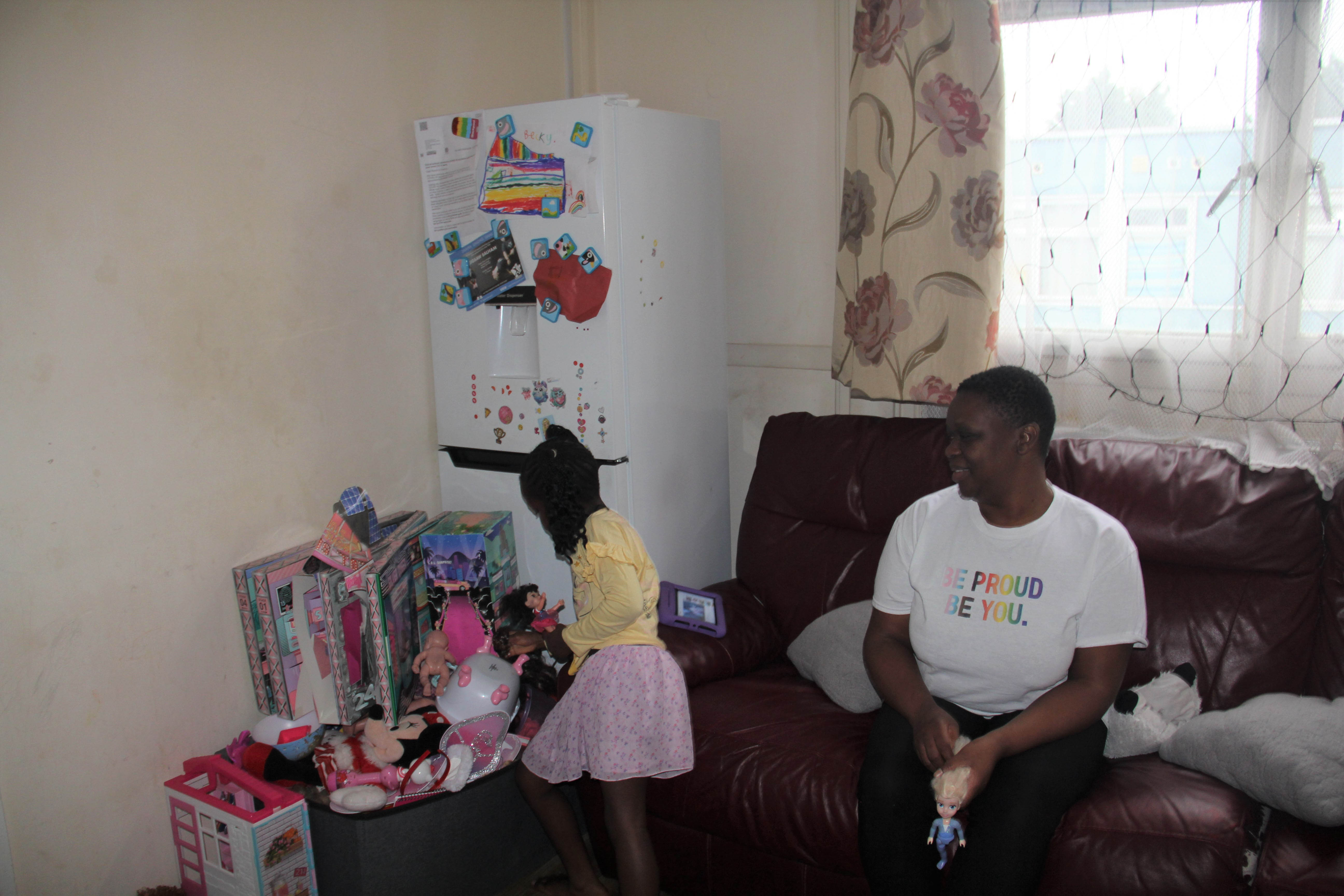 A woman watches her daughter play with toys