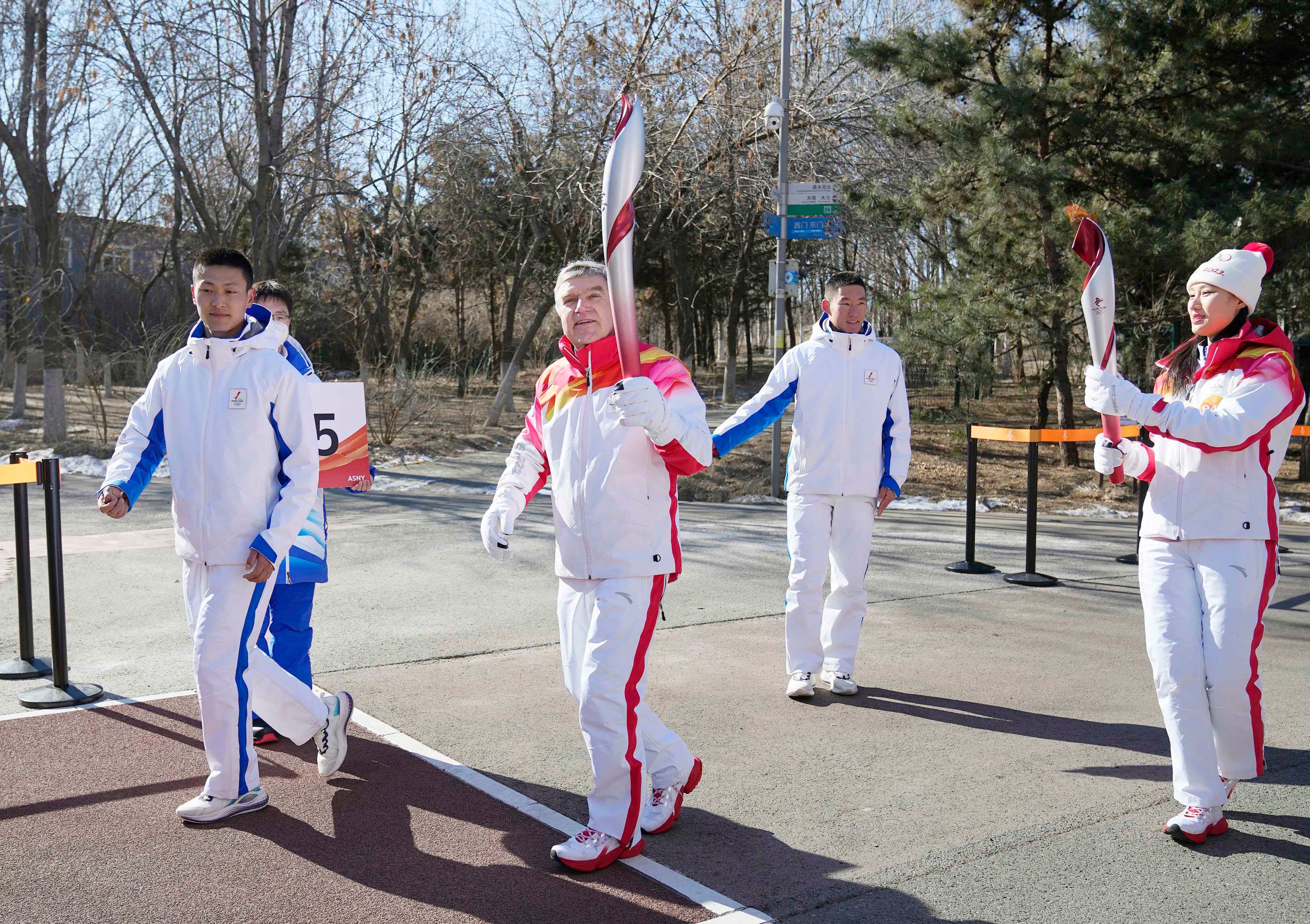 國際奧林匹克委員會主席托馬斯・巴赫（Thomas Bach，右三）在北京冬奧會開幕式當天參加火炬傳遞，中國北京，2022年2月4日。