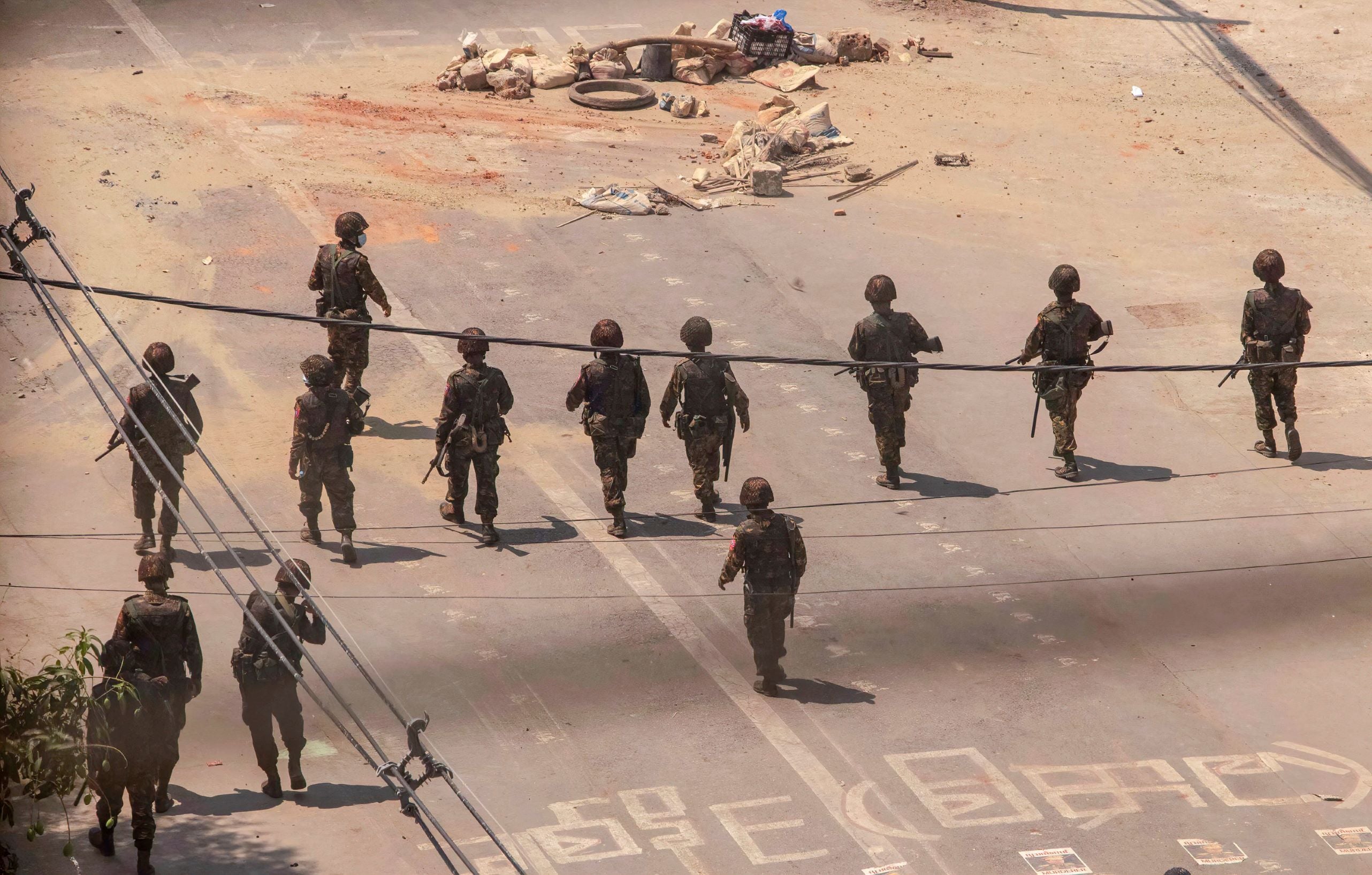 Des soldats avançaient dans une rue de Yangon, au Myanmar, lors de manifestations contre le coup d'État militaire du 1er février 2021.
