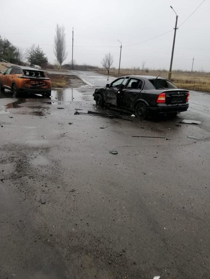 Two damaged civilian cars outside the entrance of the Central City Hospital in Vuhledar on February 25, 2022.
