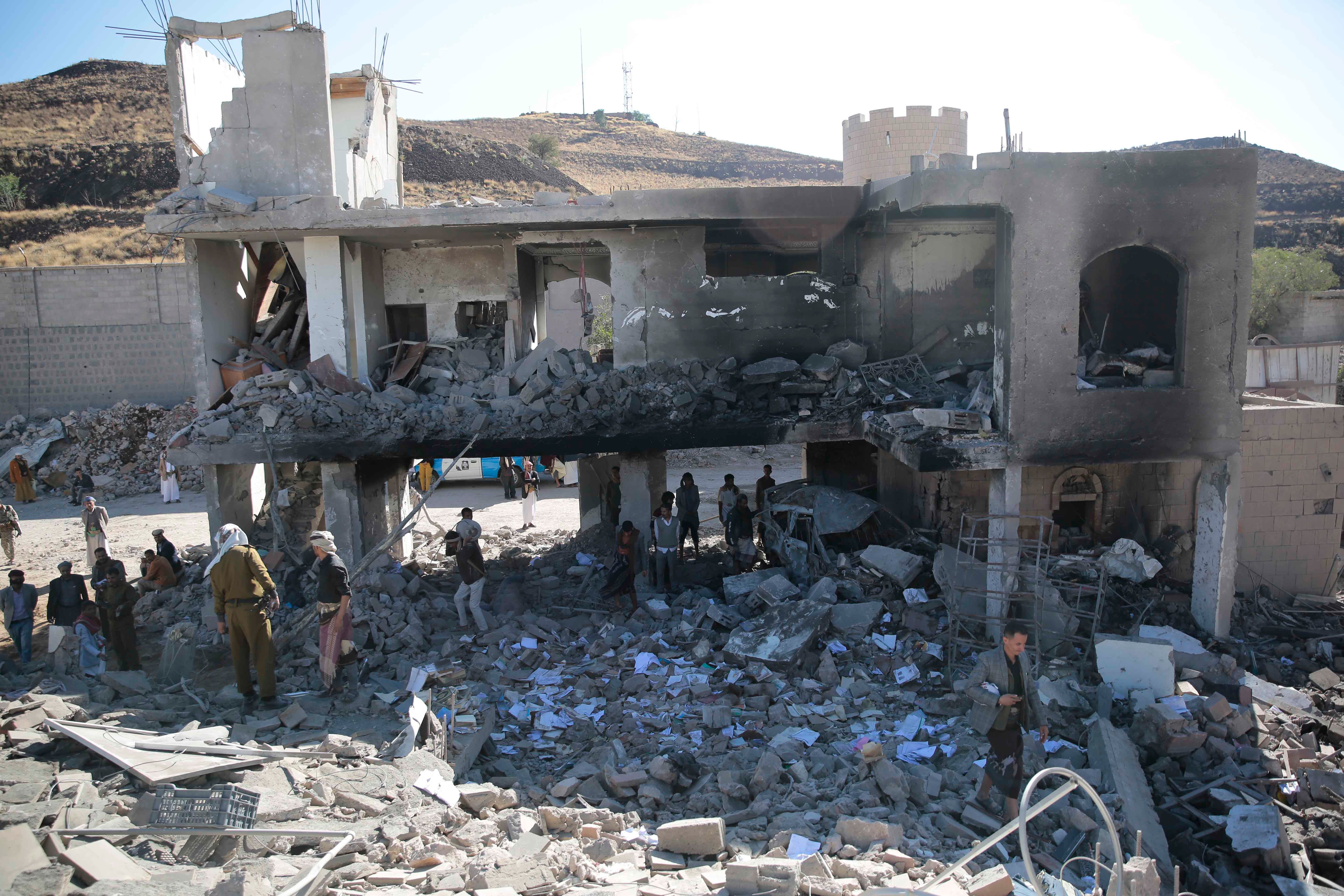 People inspect a damaged building in Sanaa, Yemen.