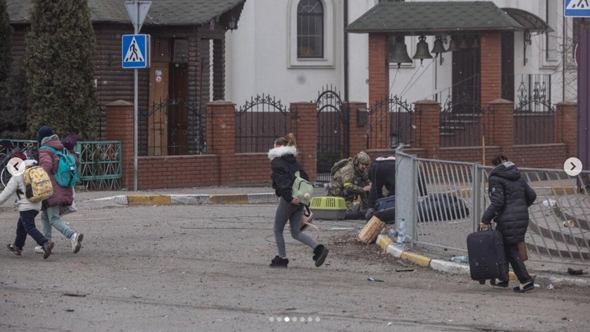 Ukrainian security forces kneel next to civilians injured and killed in one of the many attacks with explosive weapons by Russian forces