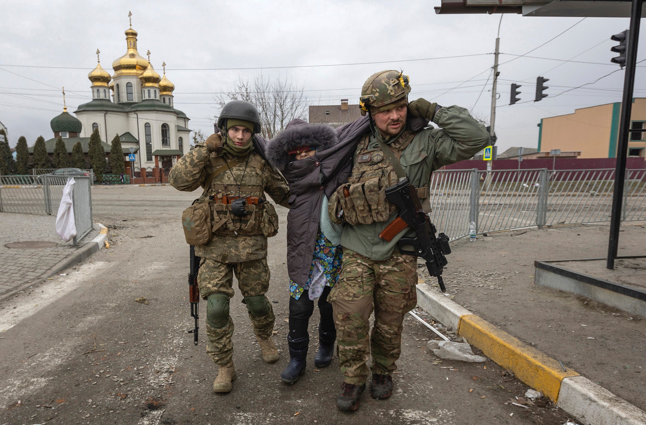 Ces deux soldats ukrainiens aidaient une femme ayant du mal à marcher, après une attaque russe à Irpin, dans le nord de l’Ukraine, le 6 mars 2022. L’attaque a été menée à un carrefour situé près de l’église orthodoxe ukrainienne Saint-Georges, alors que des civils tentaient de fuir la ville.