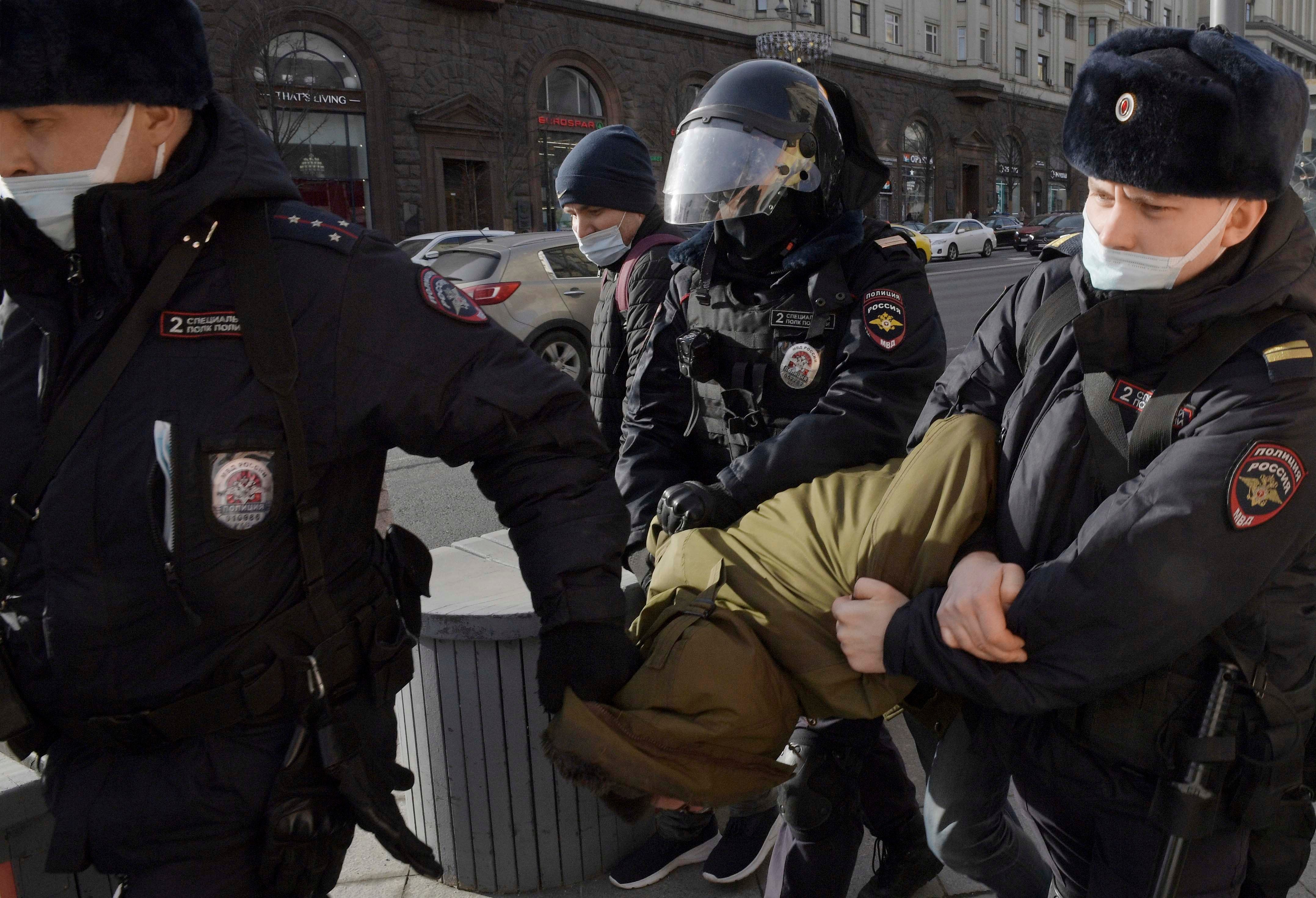 Сотрудники полиции задерживают демонстранта на Манежной площади в Москве.