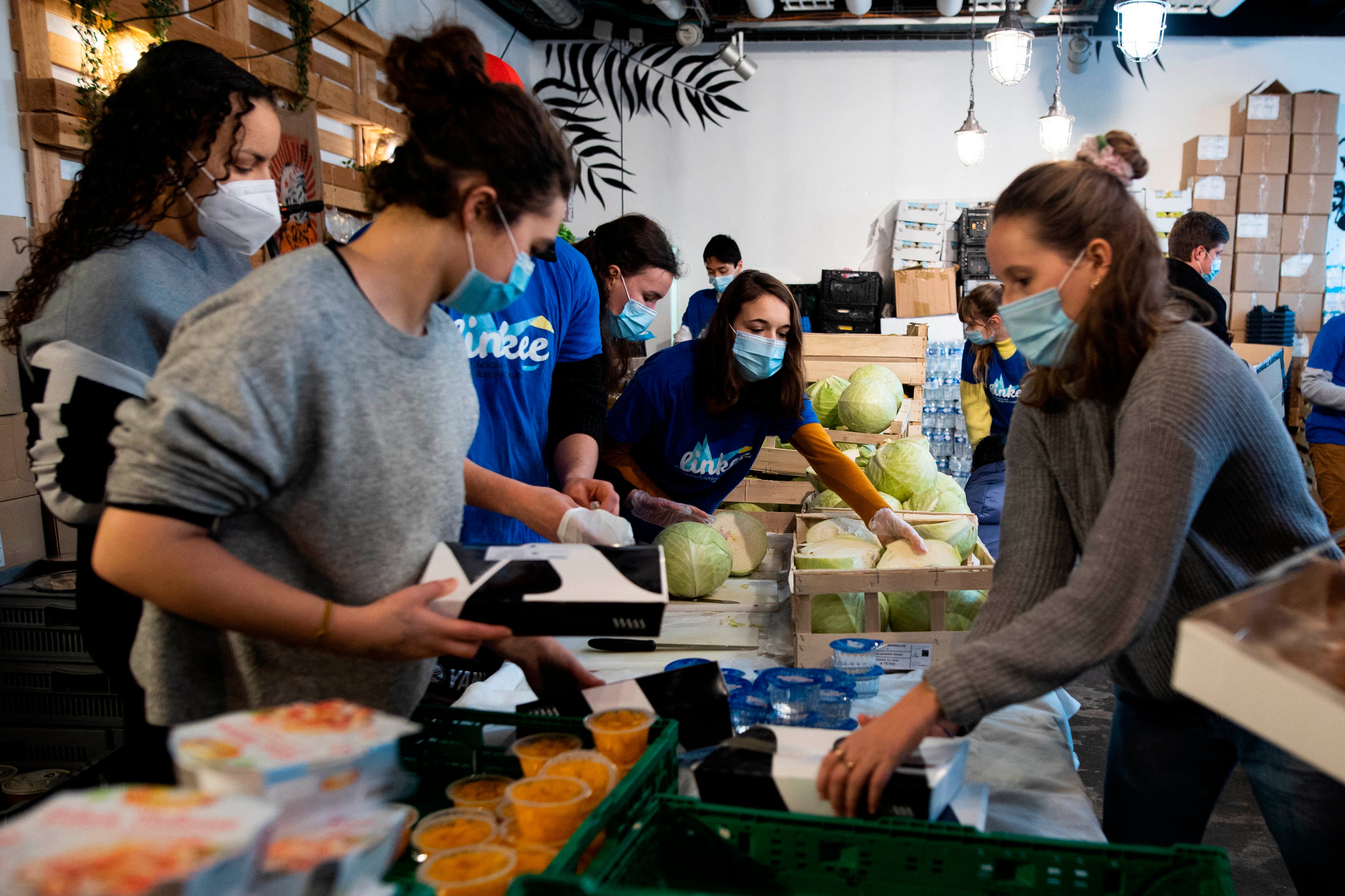 Des bénévoles de l'association Linkee préparent des boîtes de  denrées alimentaires pour des étudiants à Paris