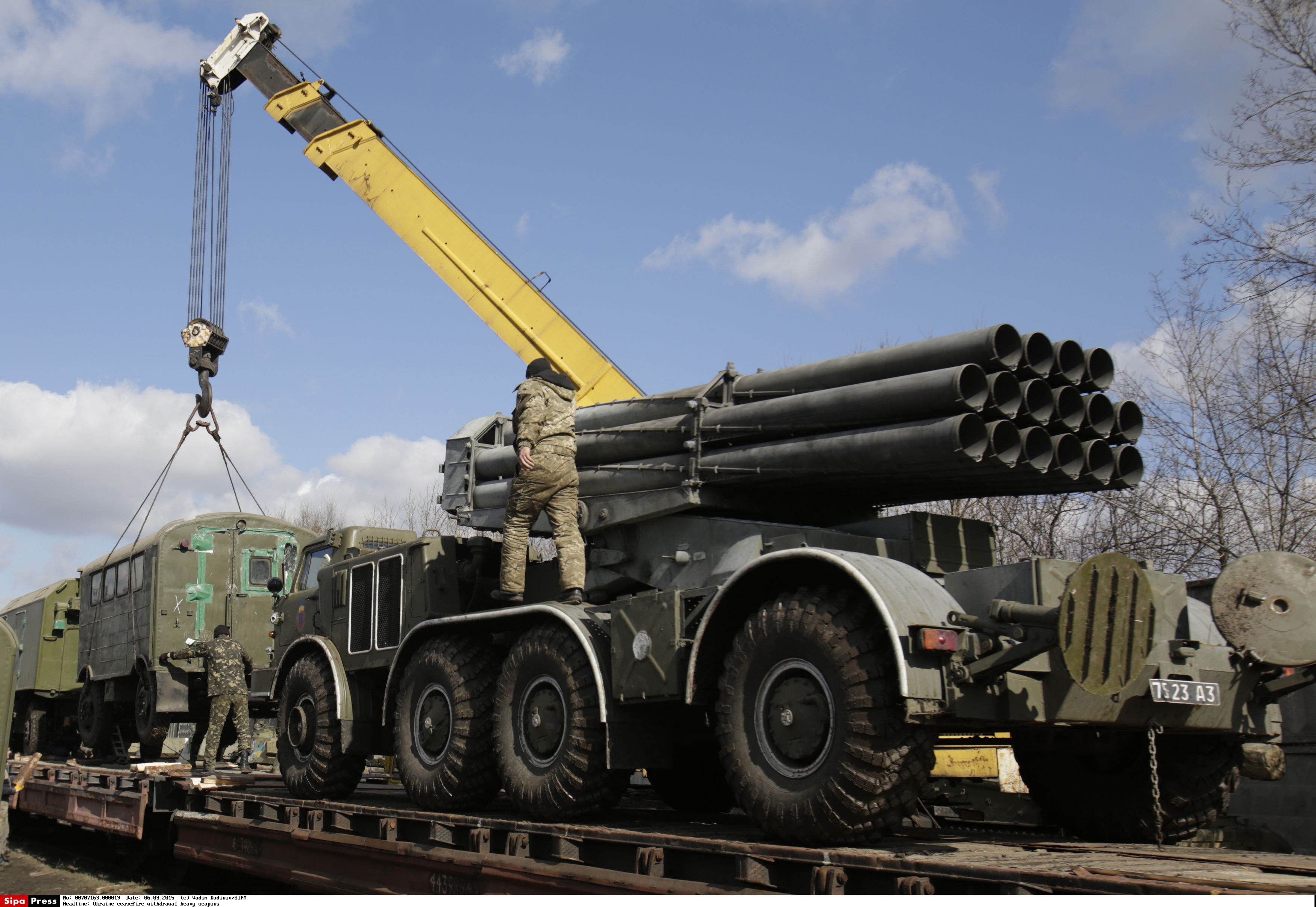 Ukrainian servicemen load a Uragan multiple rocket launcher system onto a cargo train