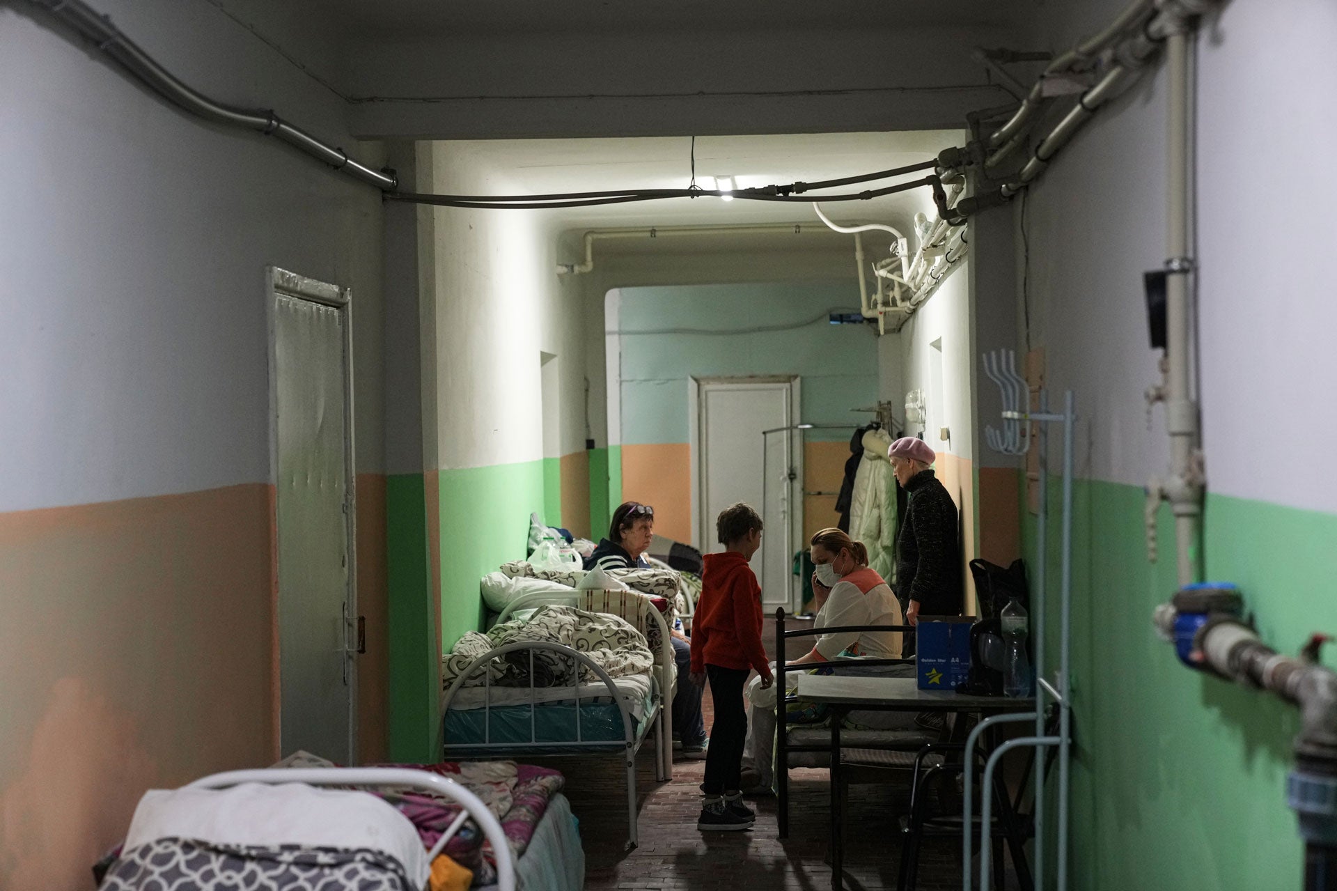 Women and their children sit in the basement of a maternity hospital converted into a medical ward and used as a bomb shelter in Mariupol, Ukraine