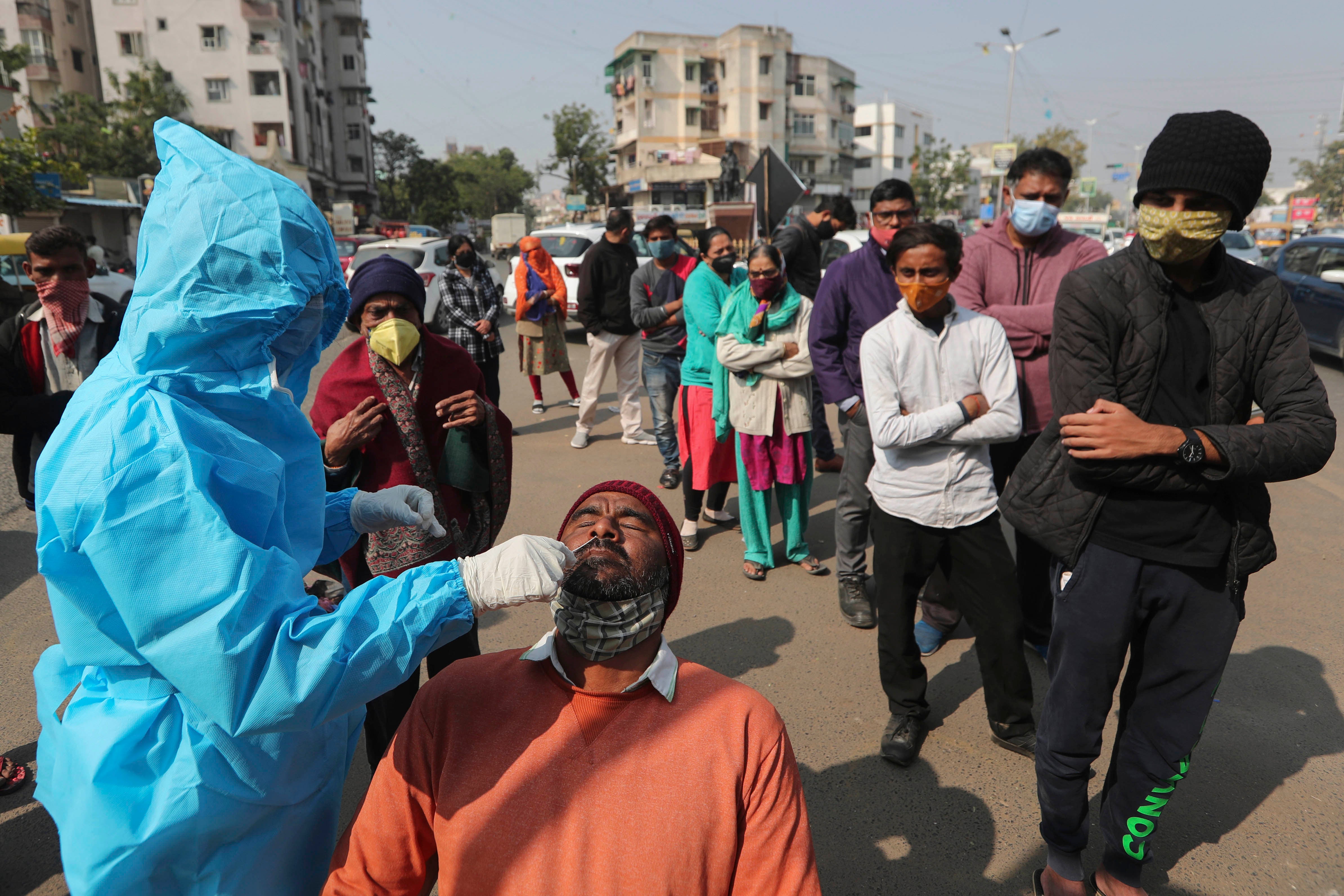 A health worker takes a swab sample of a man to test for Covid-19 in Ahmedabad, India, January 17, 2022.