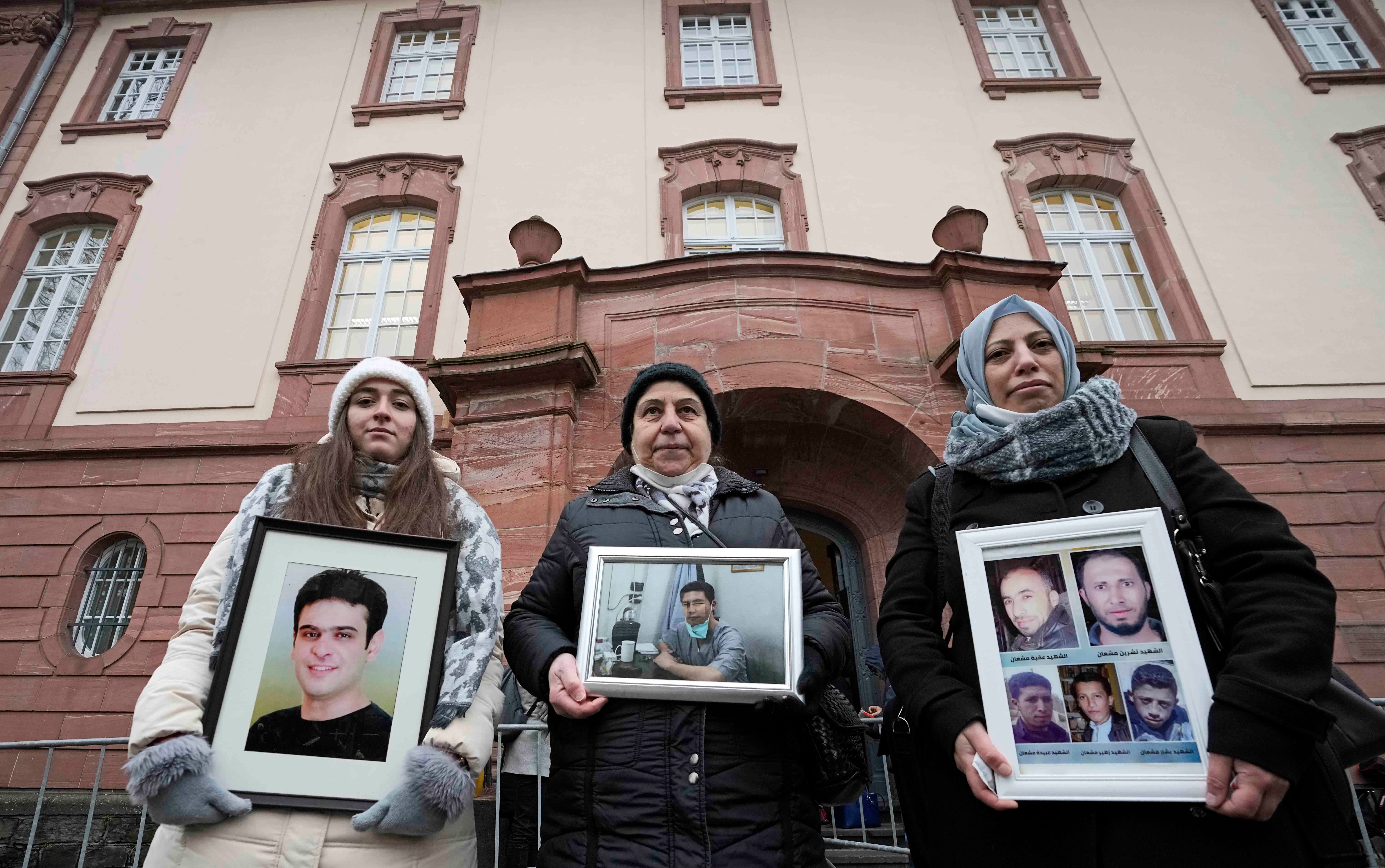 Die syrischen Frauen Samaa Mahmoud, Mariam Alhallak und Yasmen Almashan (von links) halten vor der Urteilsverkündung vor dem Gericht in Koblenz, Deutschland, Fotos von Angehörigen, die in Syrien gewaltsam verschwunden sind, 13. Januar 2022. 