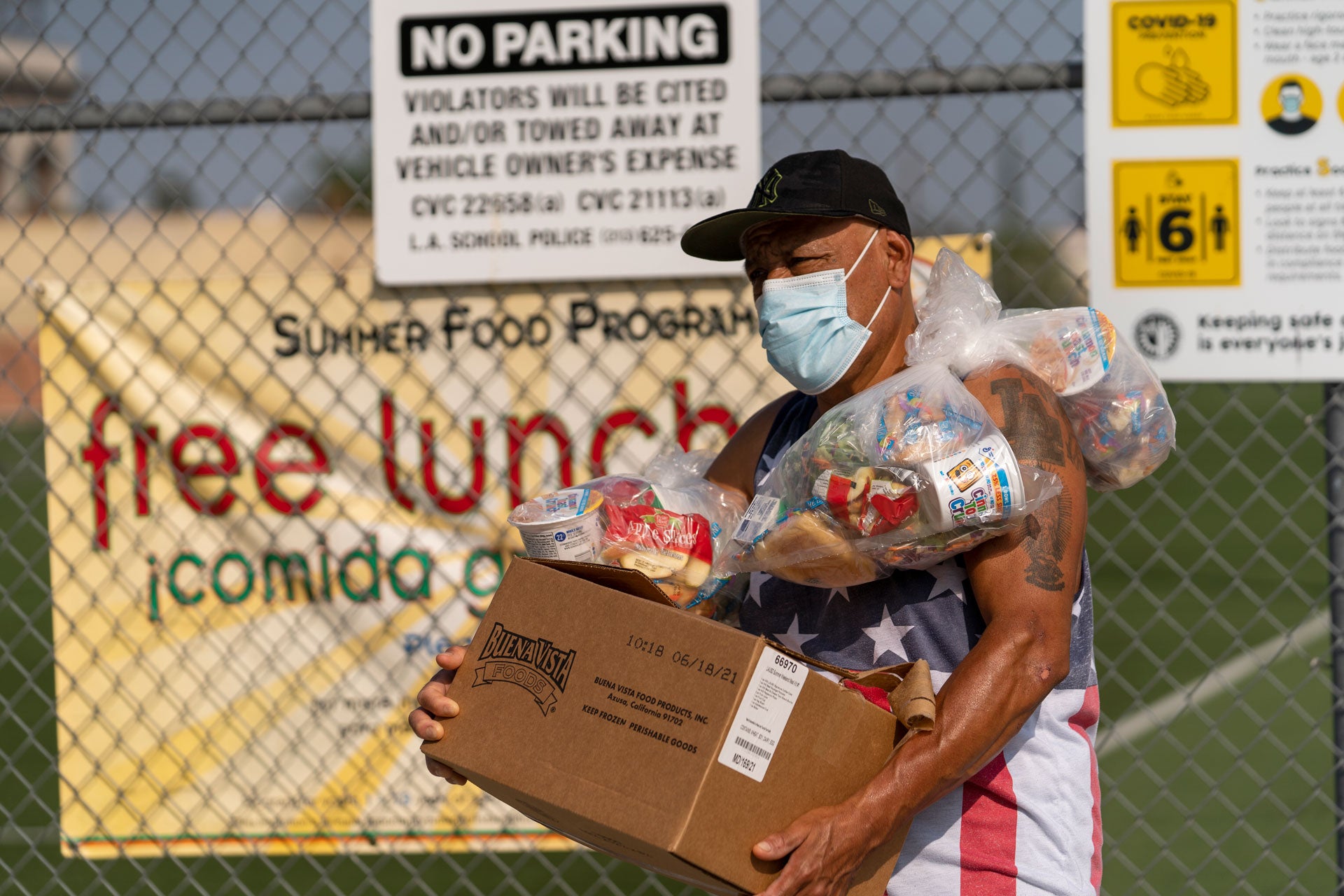 A man picks up food for his family at the Los Angeles Unified School District's Liechty Middle School in Los Angeles, California, July 16, 2021.
