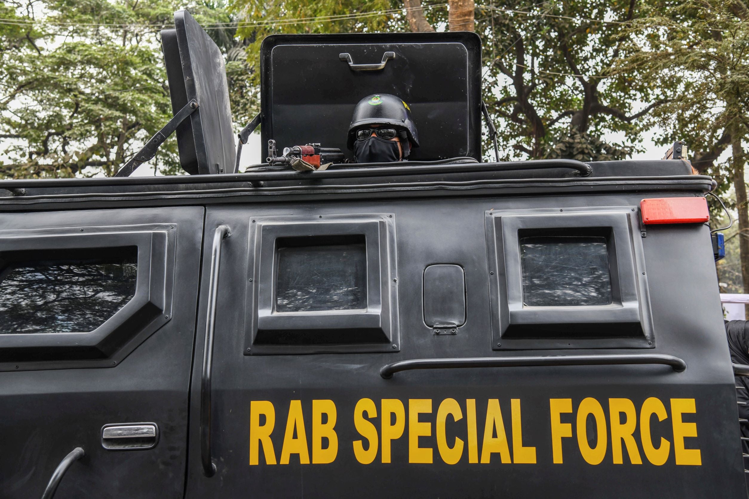 A Bangladeshi RAB (Rapid Action Battalion) member stands alert inside a truck at the Central Shaheed Minar in Dhaka, Bangladesh, February 20, 2021.