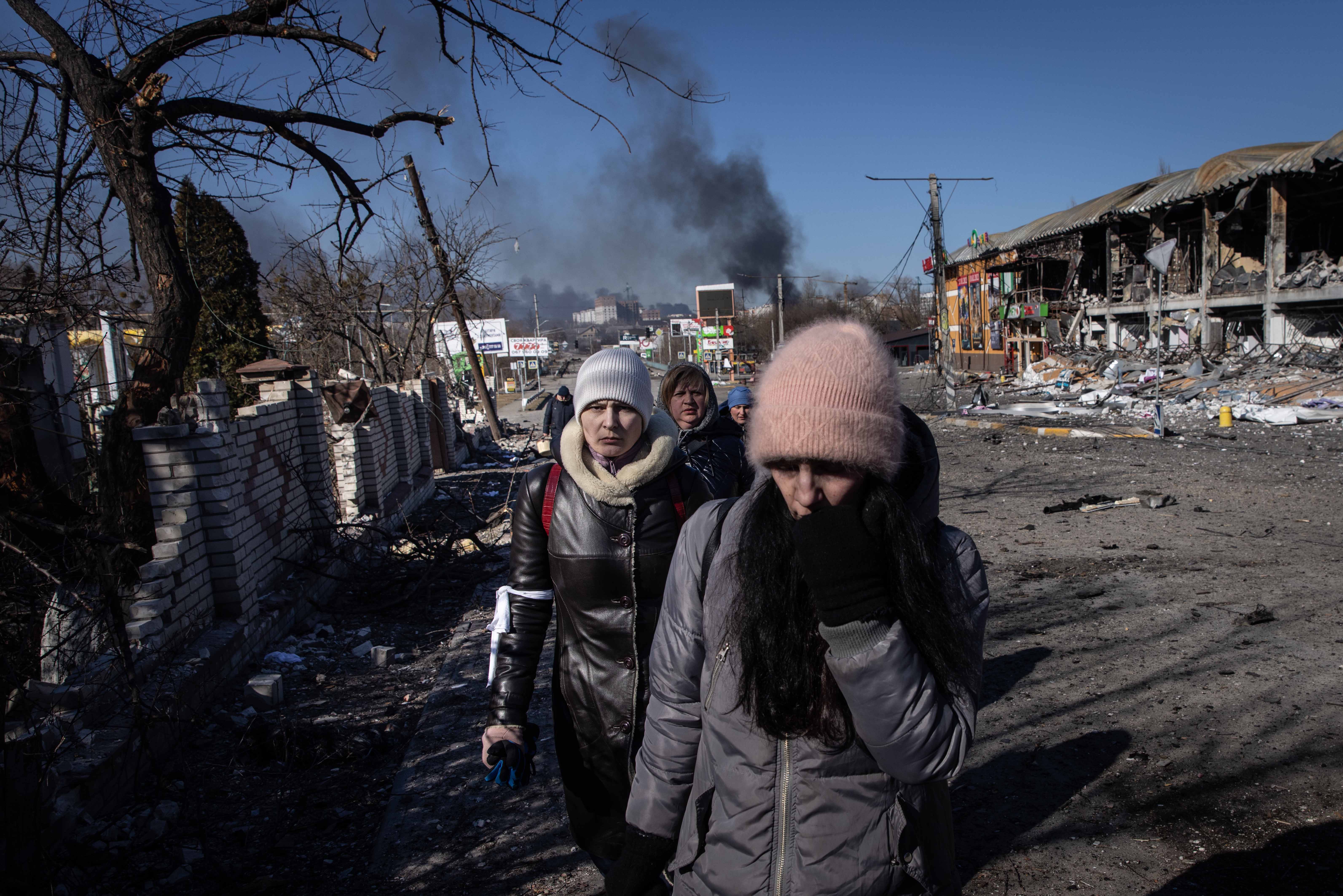 Ces habitants marchaient parmi les décombres en évacuant un quartier partiellement détruit par des frappes russes et situé entre les villes de Bucha et Irpin, à l’ouest de Kiev, en Ukraine, le 10 mars 2022. 