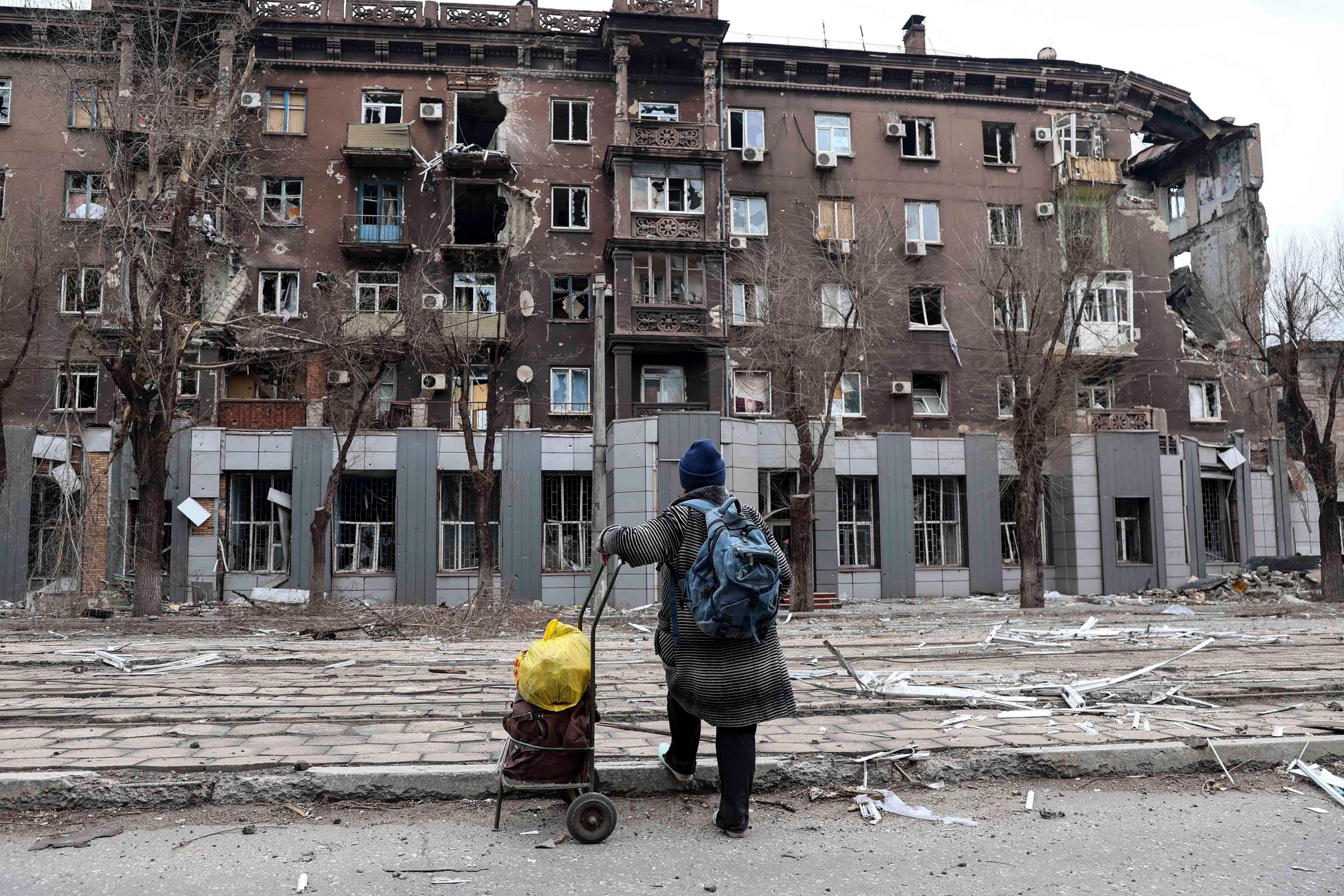 A resident looks at an apartment building damaged during heavy fighting near the Illich Iron & Steel Works Metallurgical Plant in Mariupol, Ukraine, April 16, 2022.