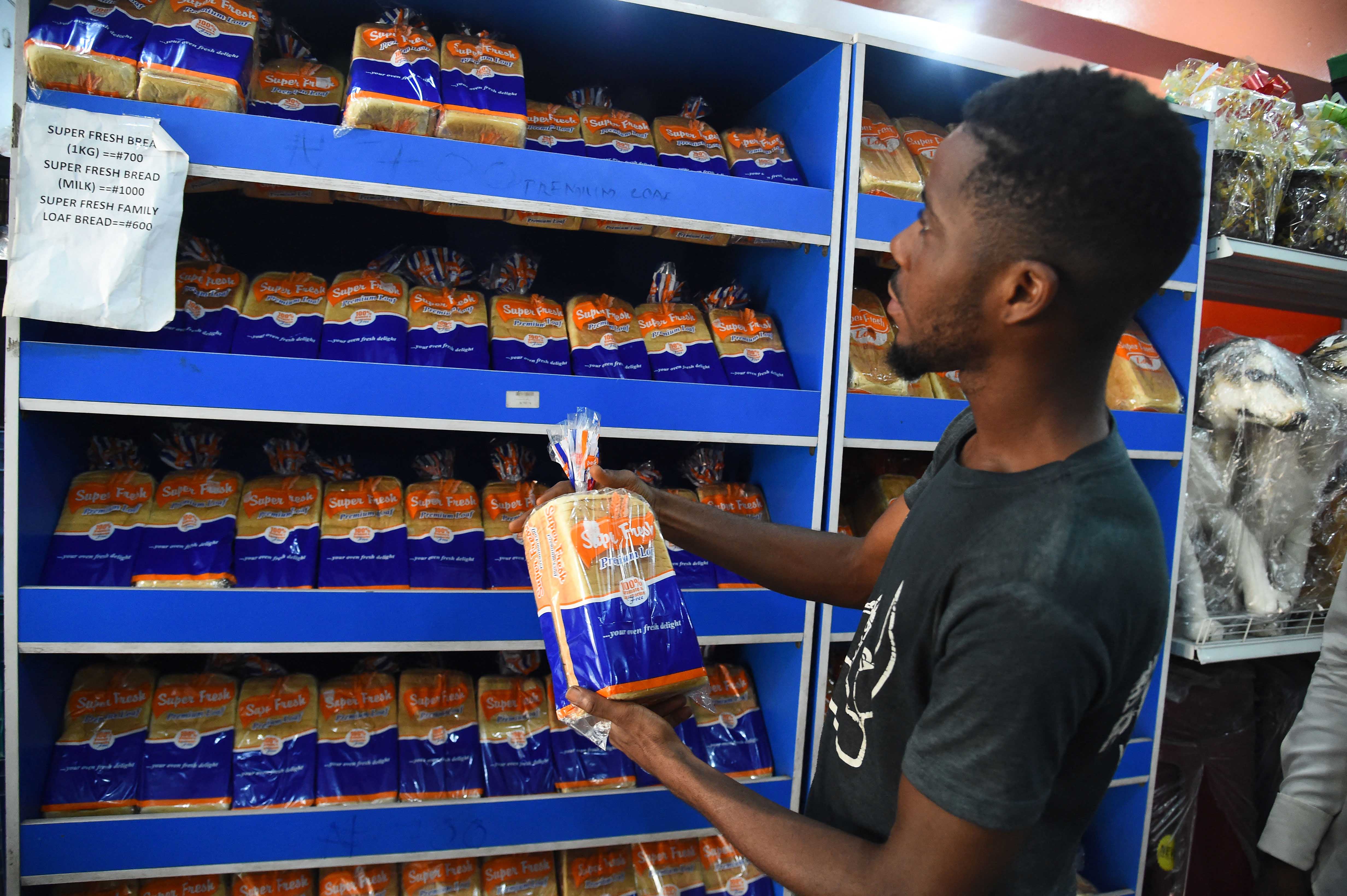 Покупатель у полки с подорожавшим хлебом в супермаркете в районе Кету в Лагосе, Нигерия, 15 марта 2022 г. 