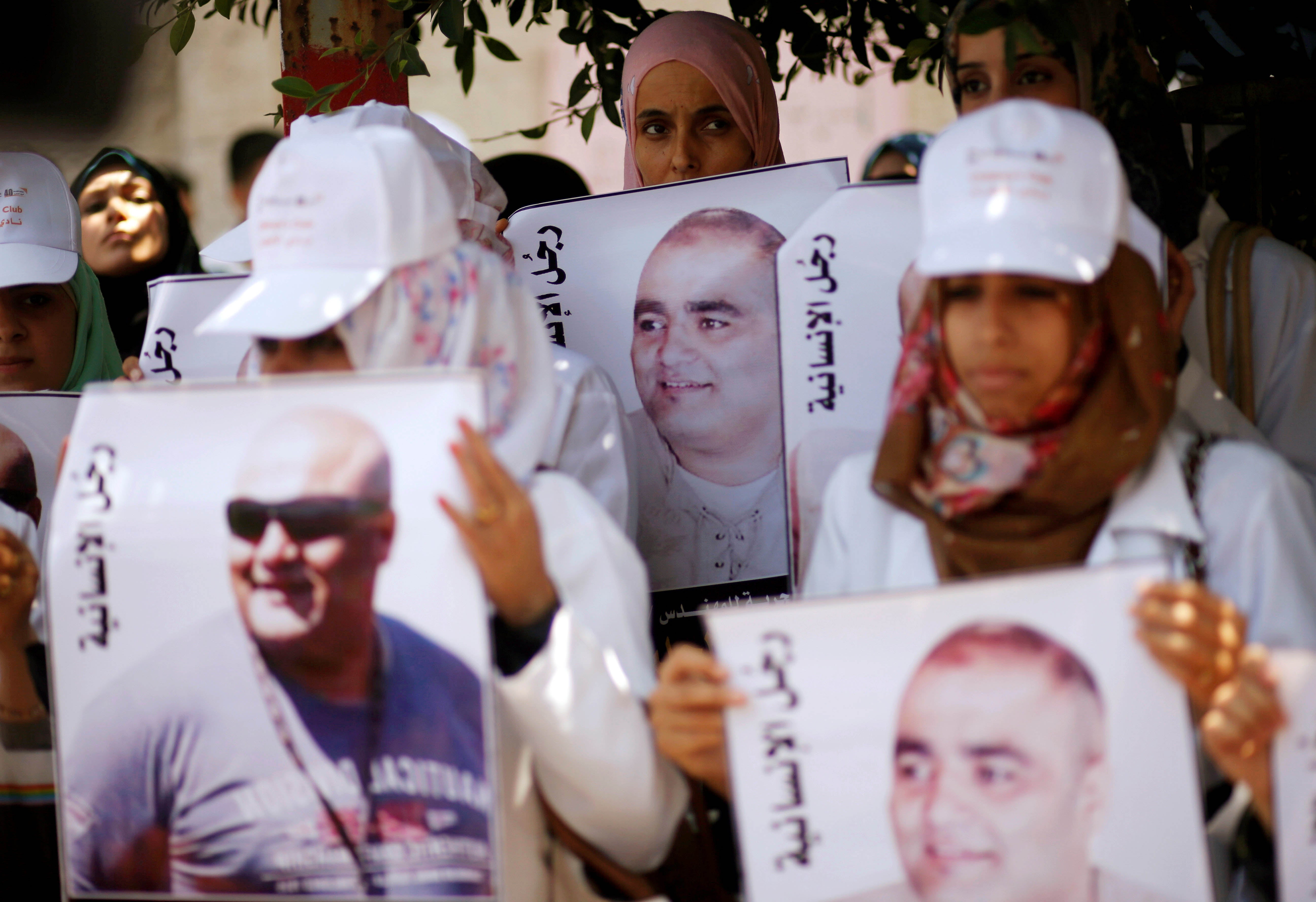 Palestinian demonstrators hold posters of Mohammad al-Halabi