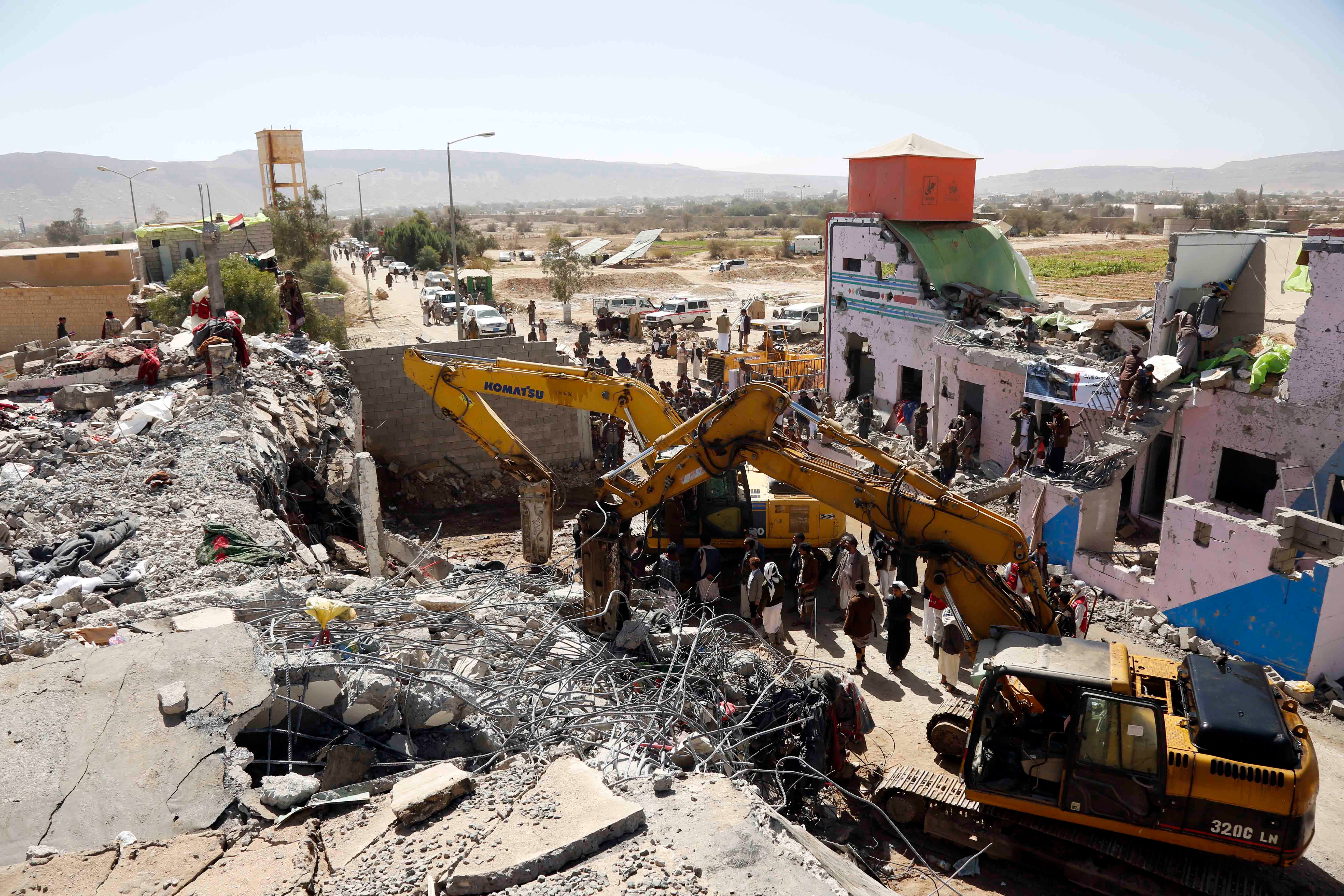 منظر لجرافات وأشخاص يتفقدون مركز الحبس الاحتياطي المدمر الذي يسيطر عليه الحوثيون في محافظة صعدة. في 21 يناير/كانون الثاني، استهدفت غارات جوية للتحالف بقيادة السعودية والإمارات المنشأة، قتلت 66 شخصا وأصابت 127.