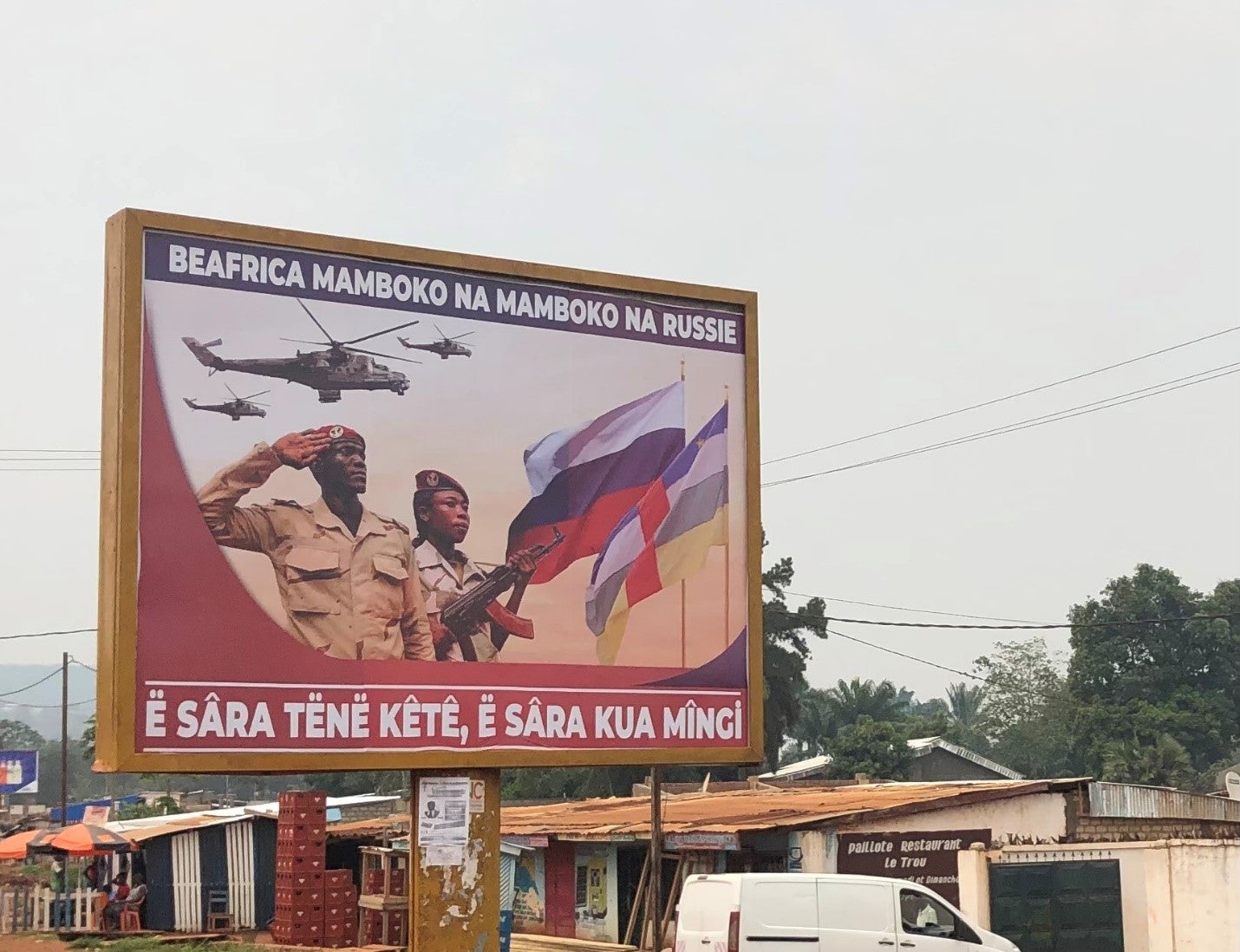 Un panneau vu à Bangui, capitale de la République centrafricaine, vantant la coopération entre ce pays et la Russie. Le texte, en langue sango, proclame : « La République centrafricaine main dans la main avec la Russie. Peu de paroles, beaucoup de travail. »  