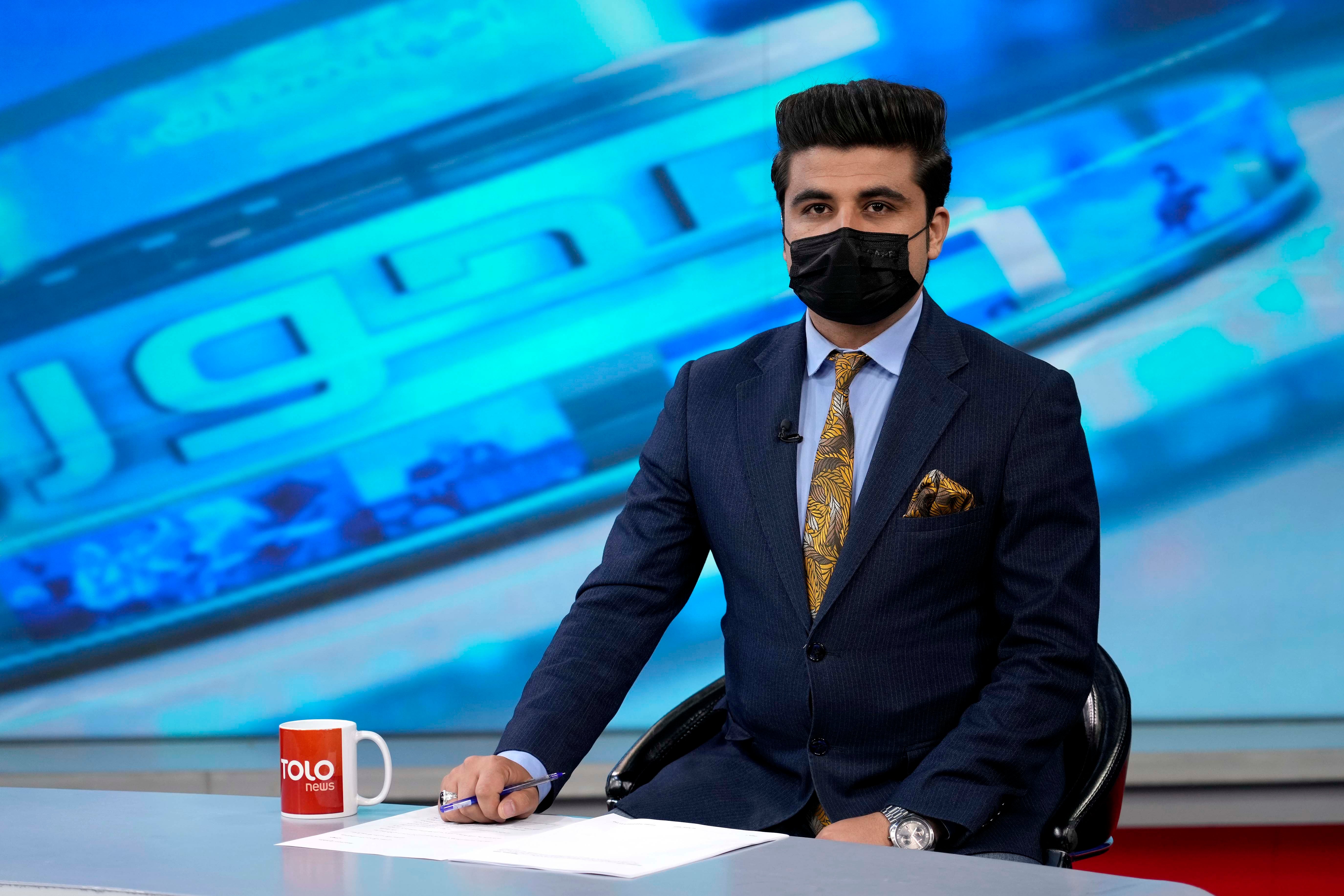 A tv anchor wears a face mask on the air