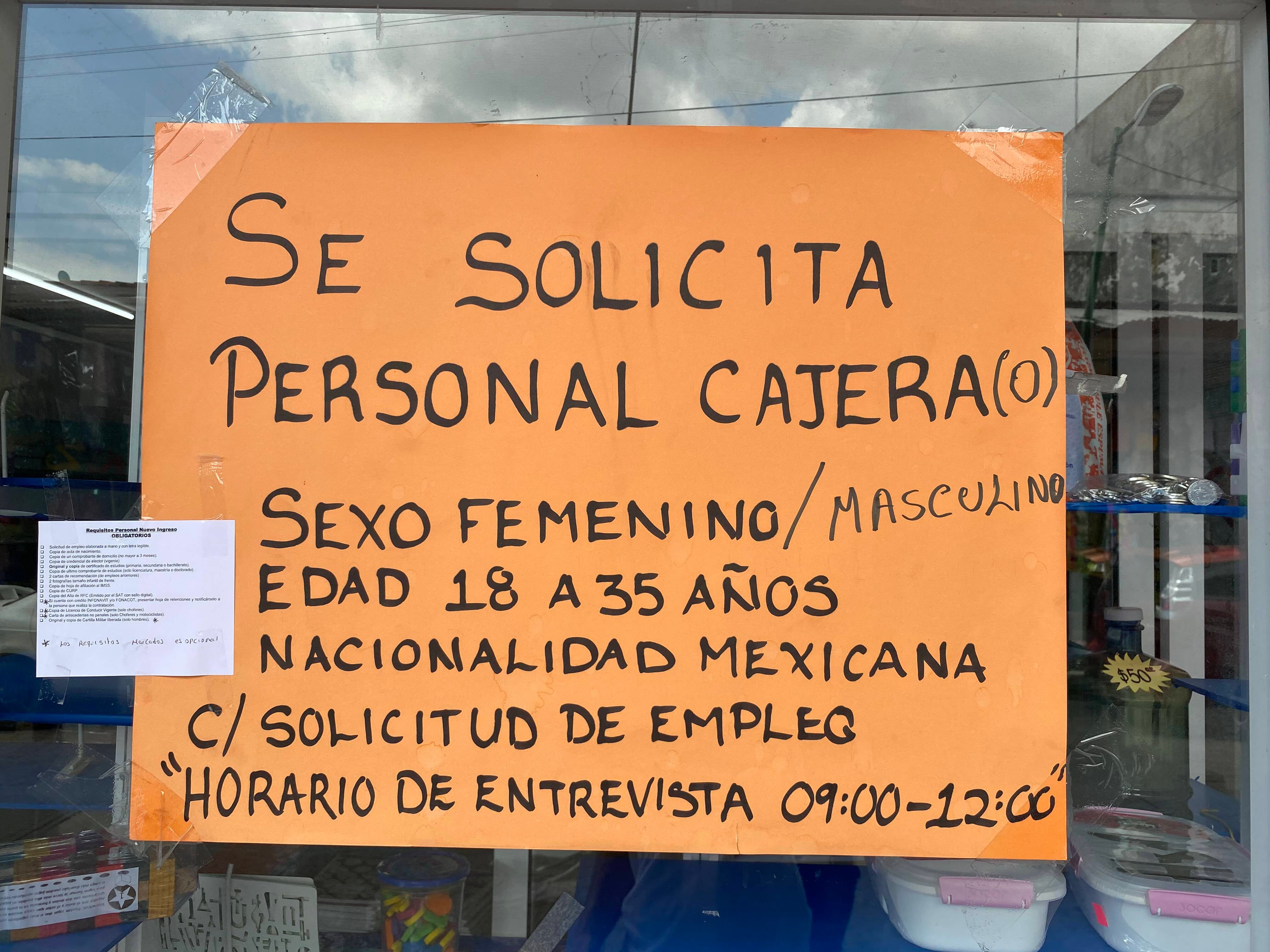 A sign posted outside a storefront in downtown Tapachula, Mexico advertises a vacancy for a job as a cashier, specifying “Mexican nationality” as a requirement to apply, August 15, 2021.